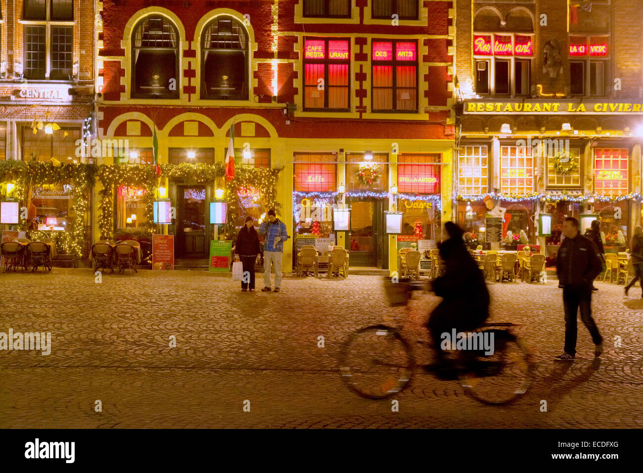 Ein Radfahrer Radsport vor eingerichteten Cafés zu Weihnachten, der Marktplatz (Markt), Innenstadt von Brügge, Belgien-Europa Stockfoto