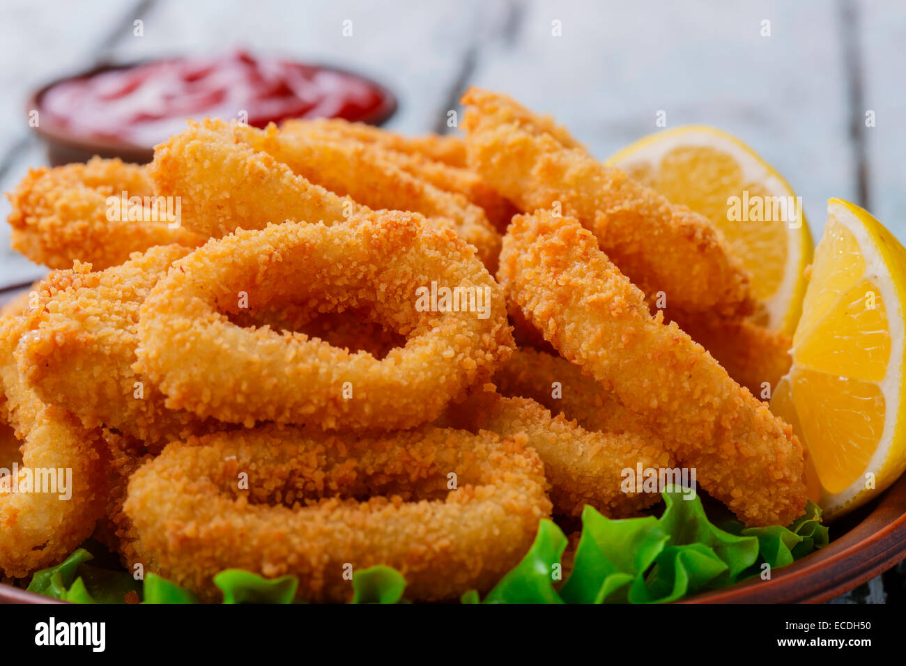 frittierte Tintenfischringe paniert mit Zitrone Stockfoto