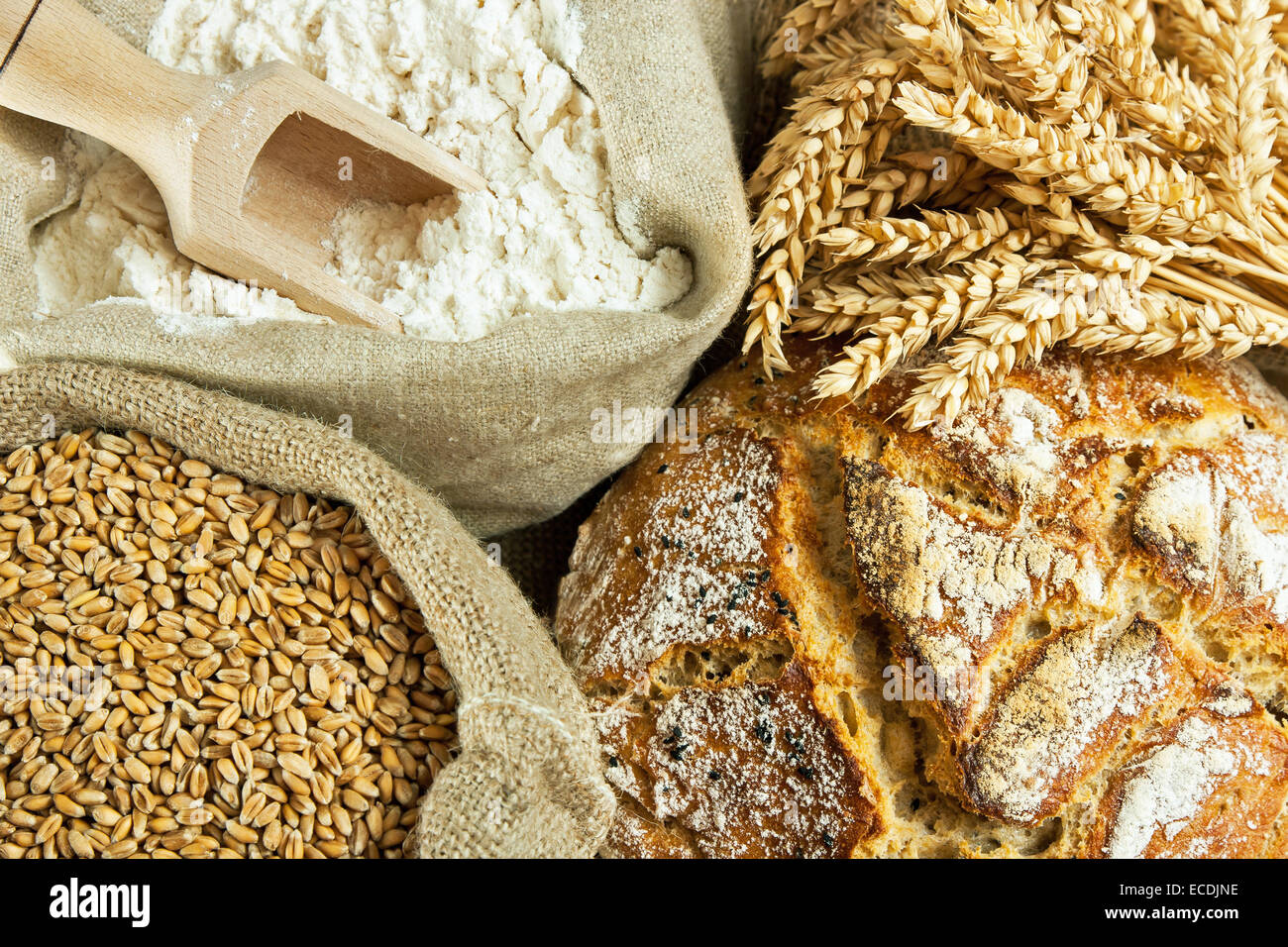 Laib Brot, Mehl, Weizen und Weizen Spike auf Tisch Stockfoto