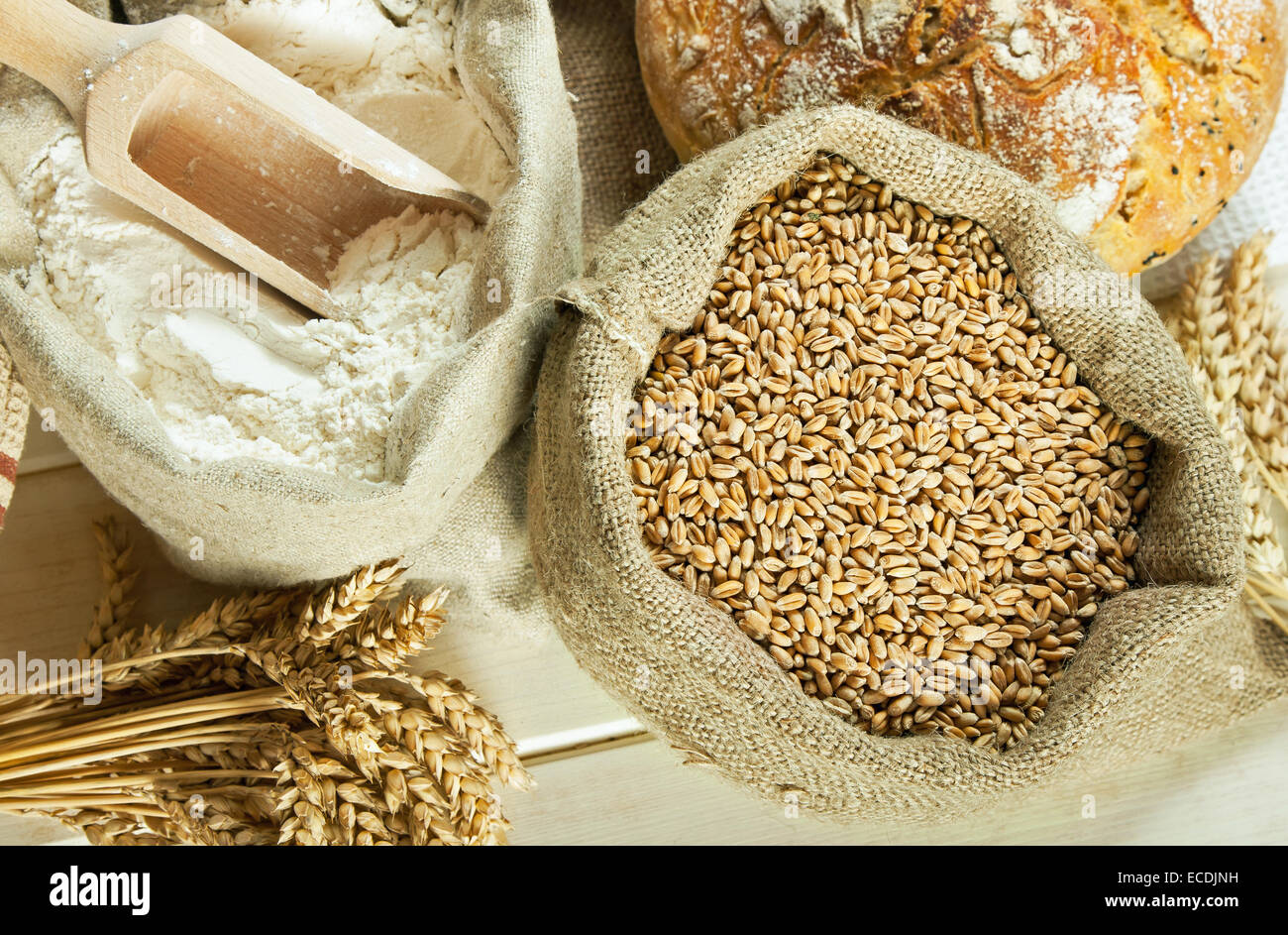 Laib Brot, Mehl, Weizen und Weizen Spike auf Tisch Stockfoto