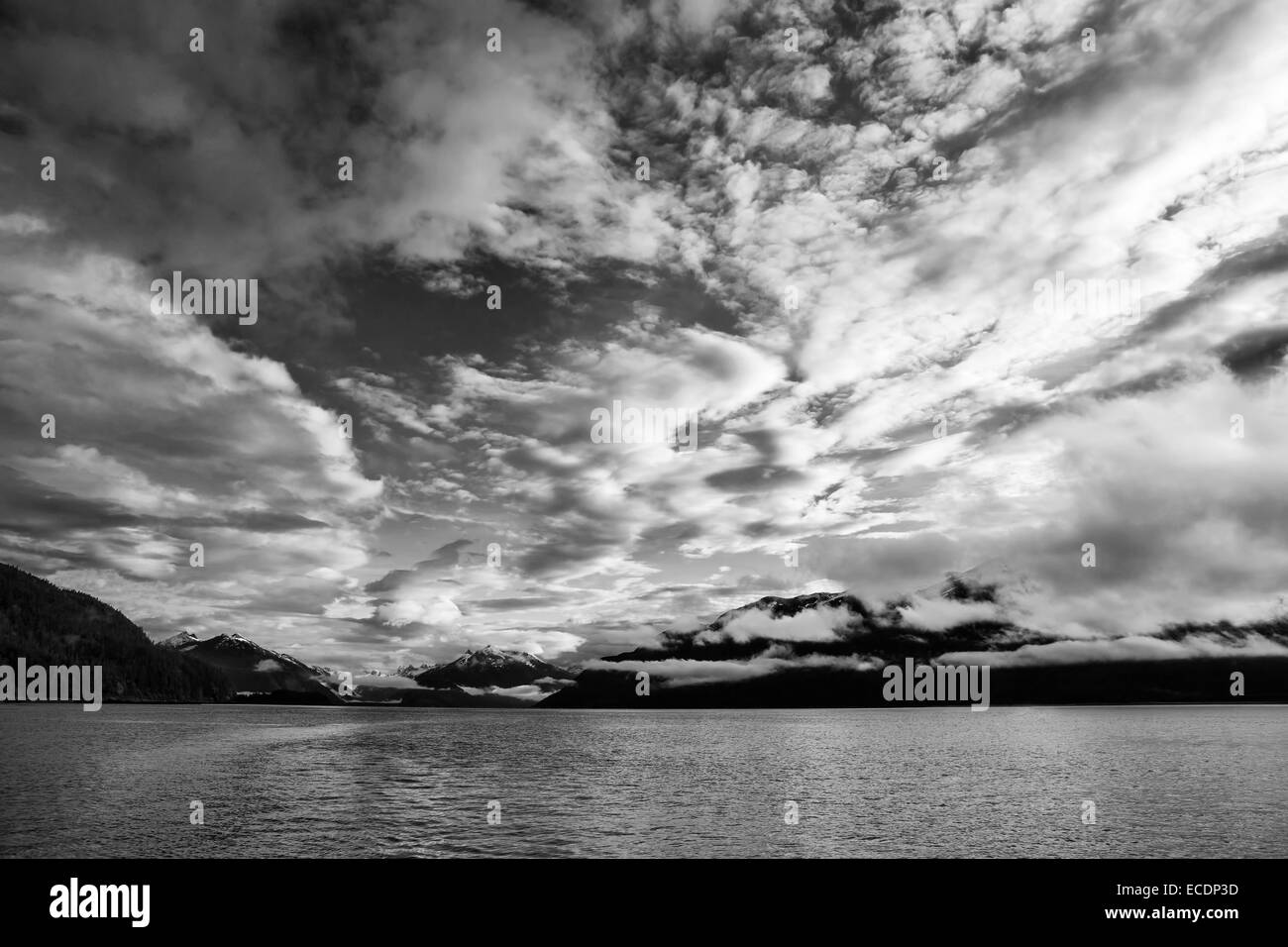 Dramatische Wolken bei Sonnenuntergang in Southeast Alaska in schwarz und weiß. Stockfoto