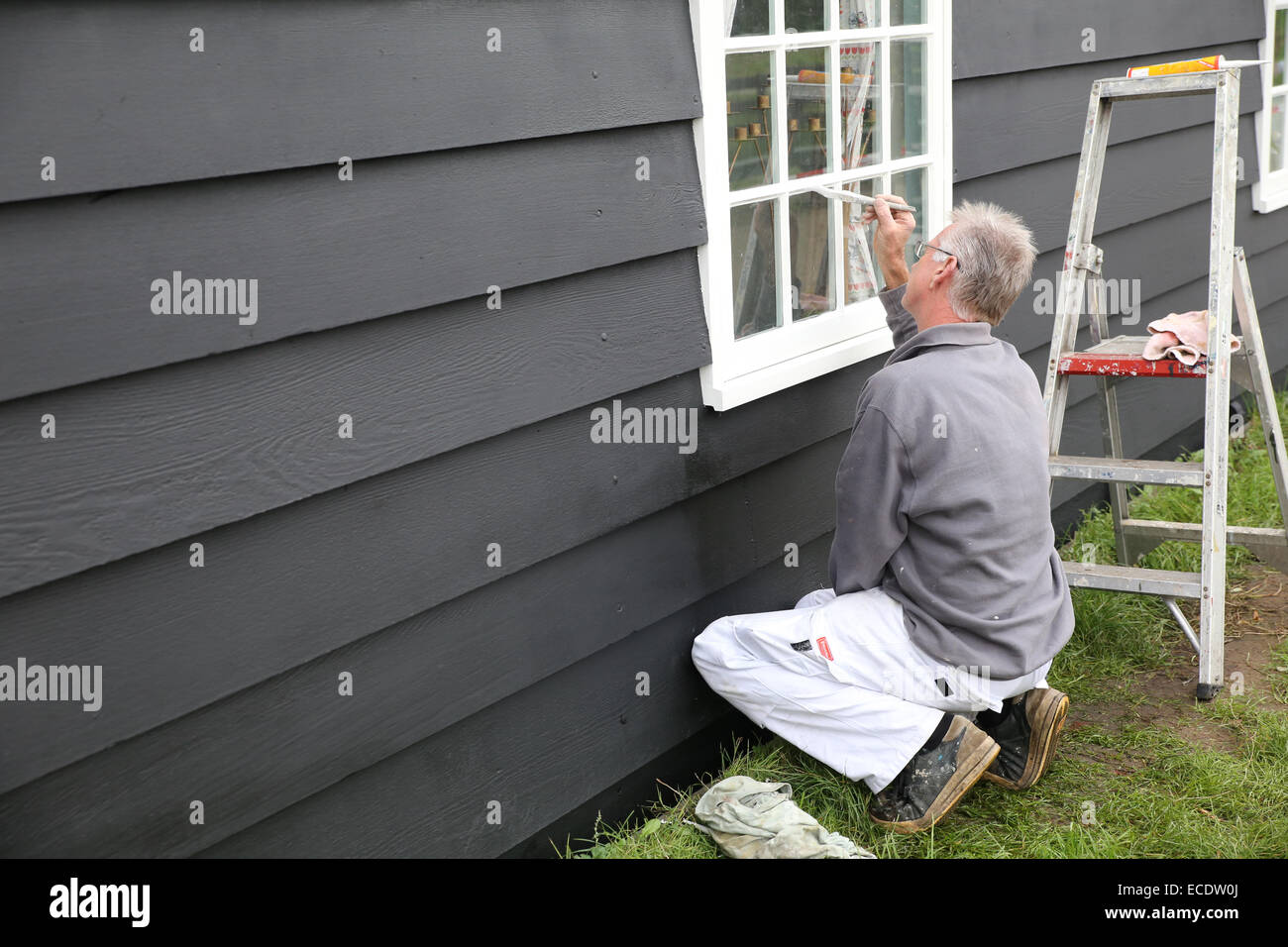 alte weiße Mann Malerei Haus Stockfoto