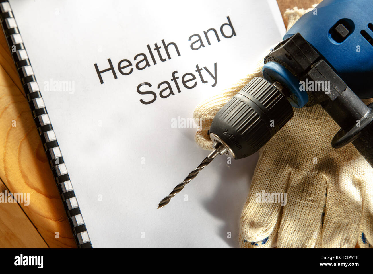 Registrieren Sie mit Bohrer und Handschuhe auf hölzernen Hintergrund Stockfoto