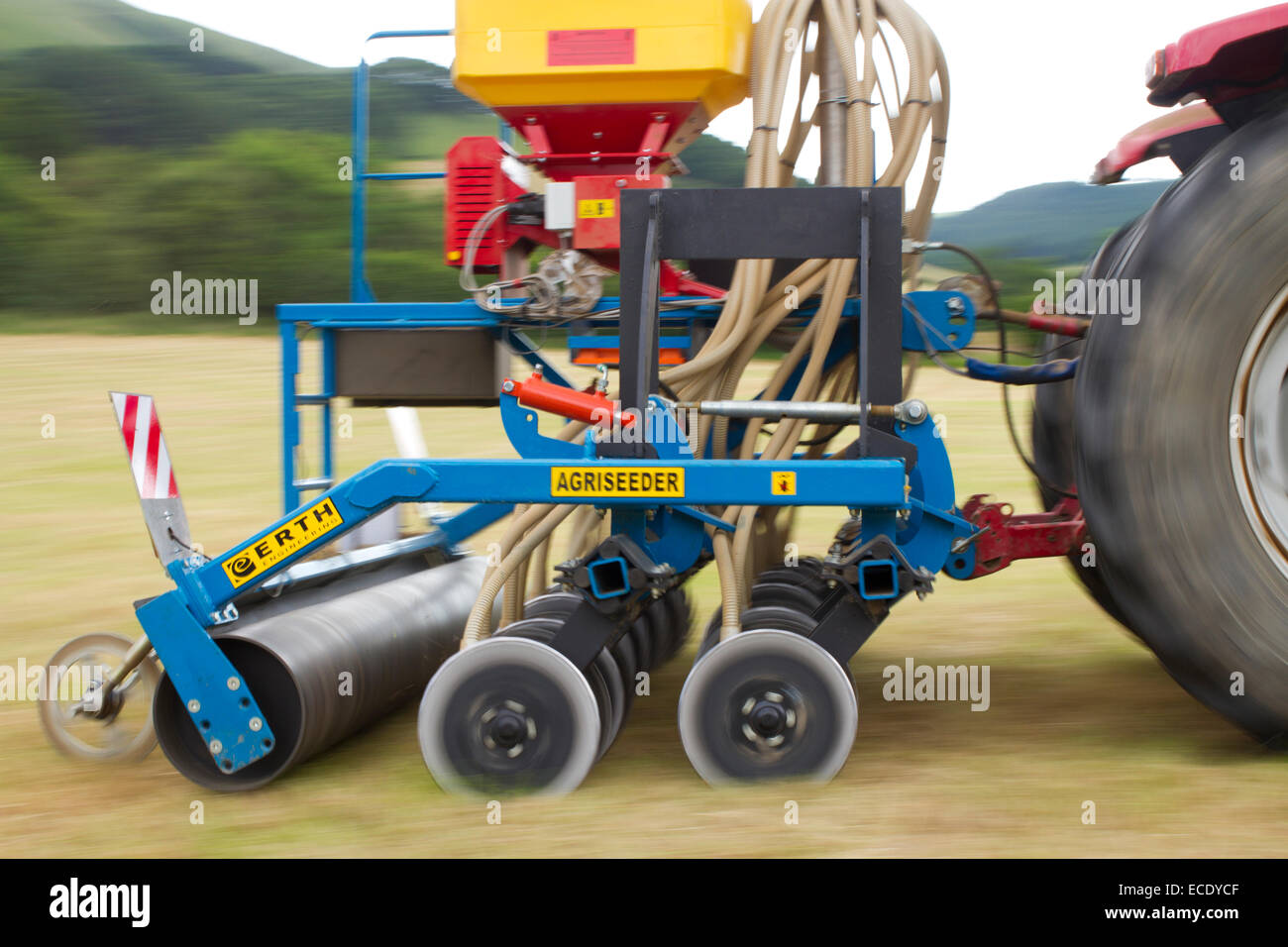 Auftragnehmer mit einem MC120 McCormick-Traktor und ein Erth Agriseeder Präzision Slot Sämaschine Bohren Klee Samen in ein Feld. Stockfoto