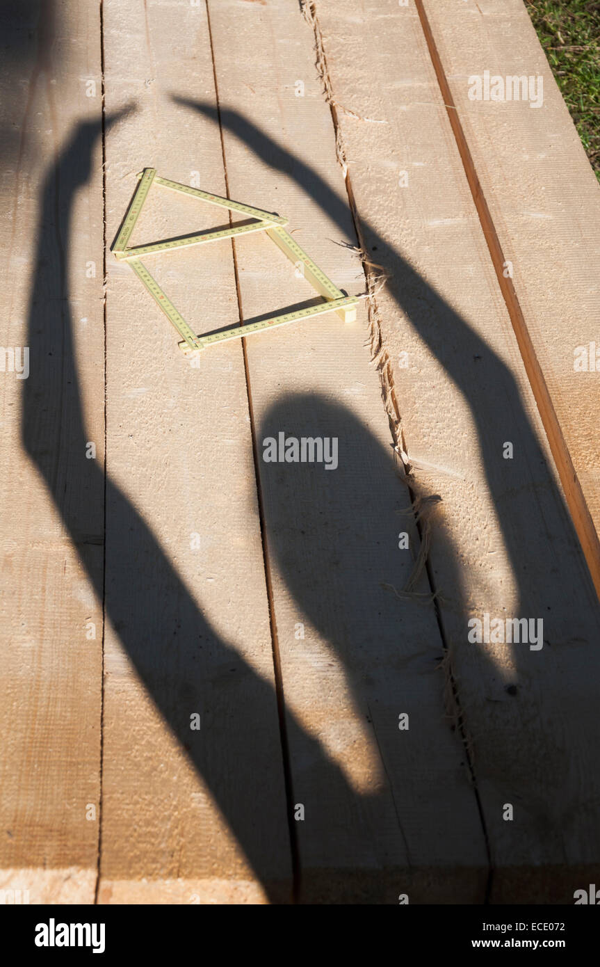 Schatten der Person auf Holz neben Falten Herrscher Stockfoto