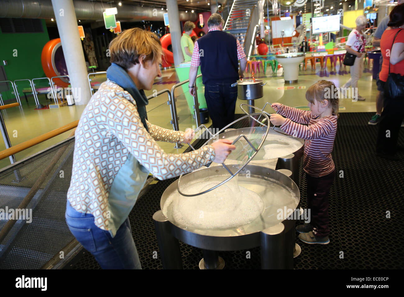 Mutter Tochter spielen Seifenwasser in Science Center museum Stockfoto