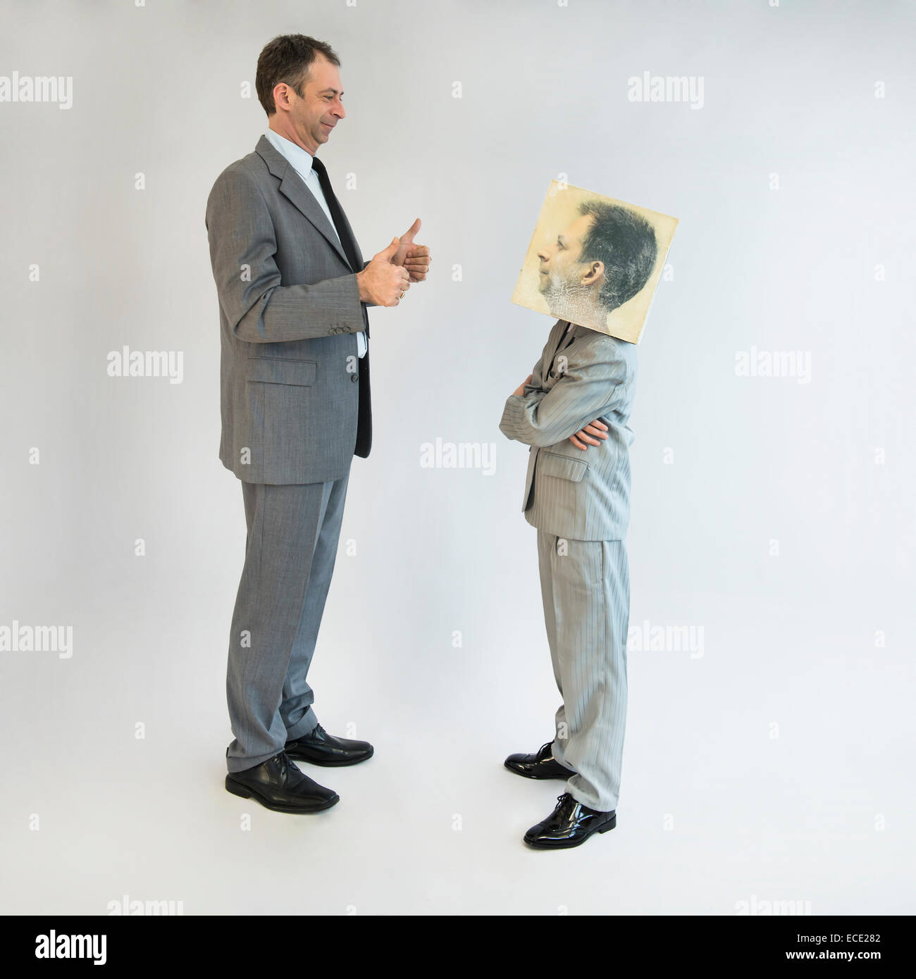 Geschäftsmann, der dem Jungen die Daumen zeigt, der eine Maske trägt Stockfoto