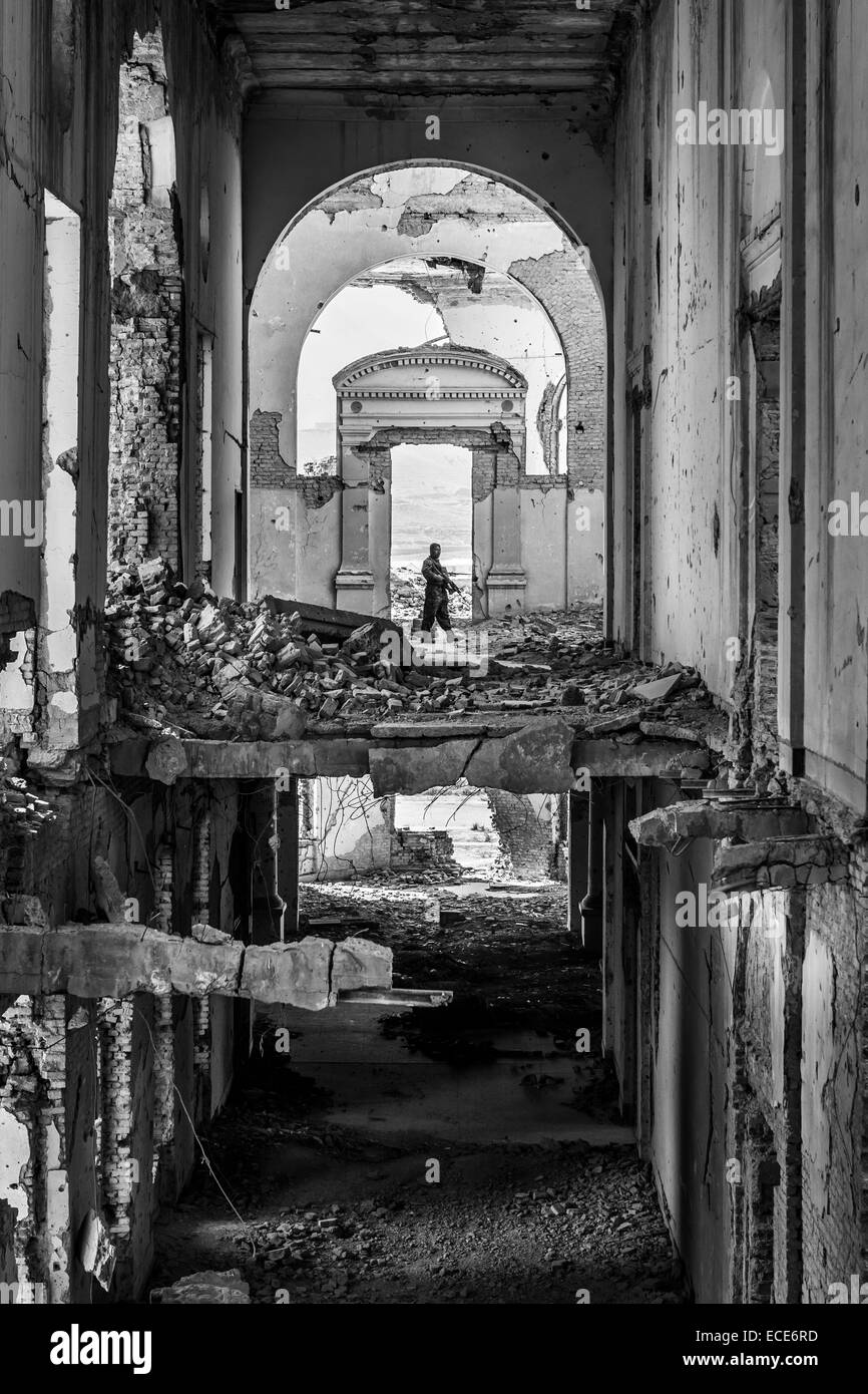 Ein Wachmann patrouilliert die Ruinen der Darulaman Palace, Kabul, Afghanistan, Oktober, 2013 Stockfoto