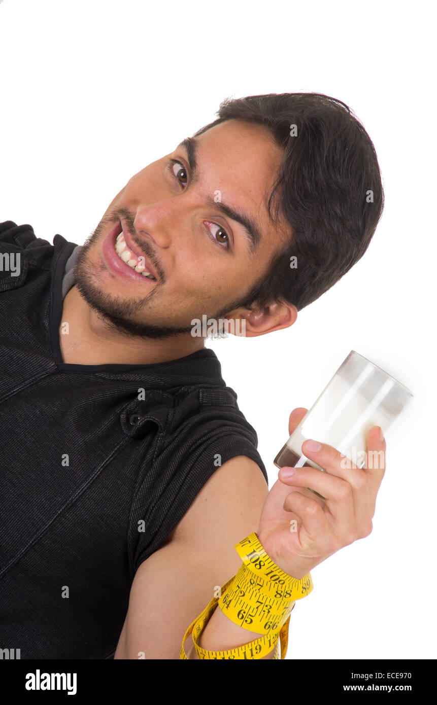 hübscher lächelnder athletischer junger Mann umwickelt Maßband mit Glas Milch Stockfoto