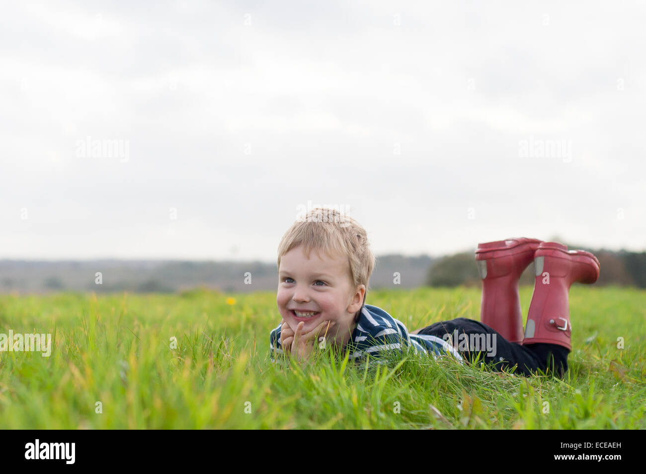 Junge im Grass liegen Stockfoto