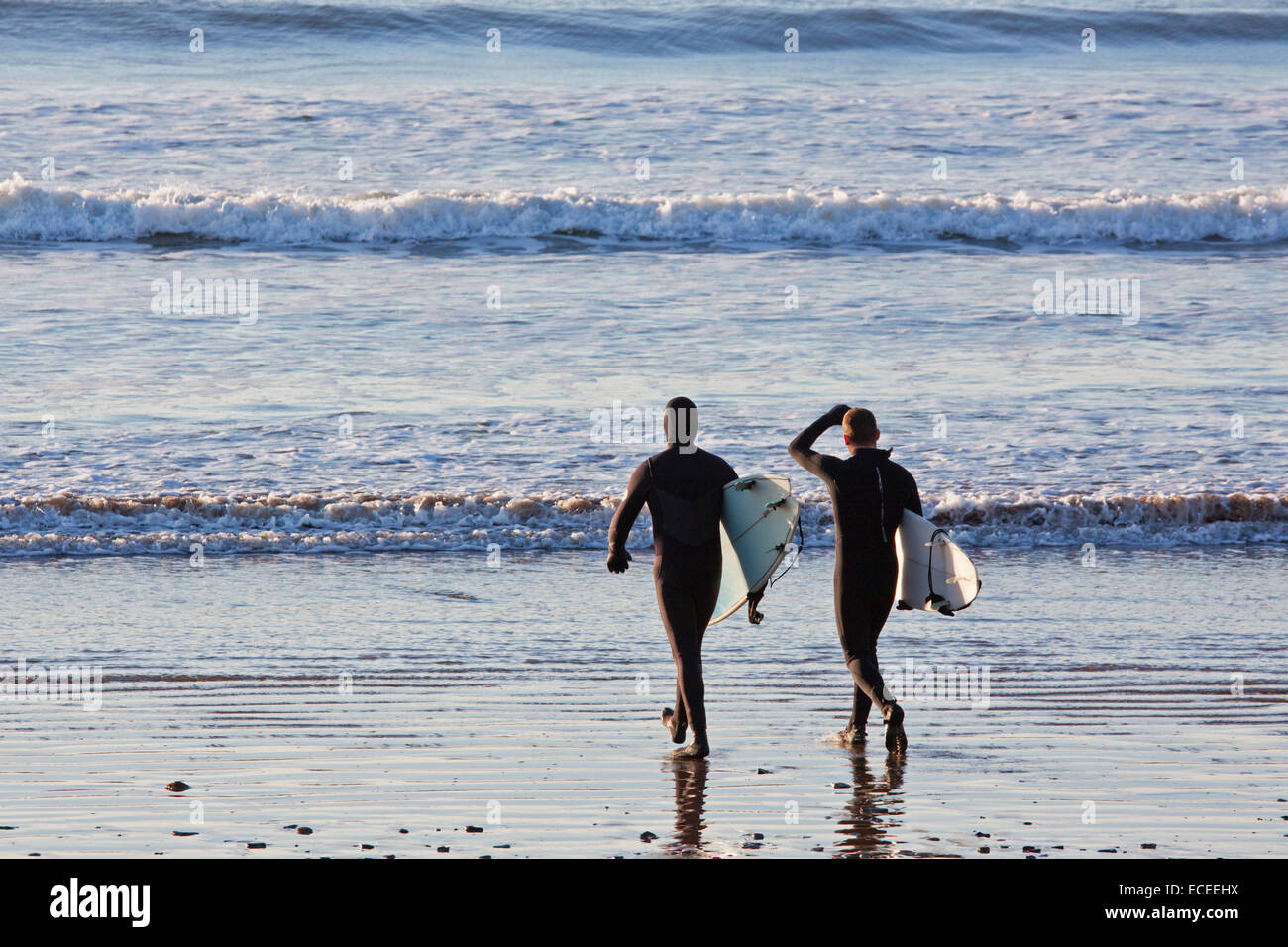 Zwei Surfer auf Saunton Sands UK vor dem Eintritt in das Wasser zu eine Sitzung der Wellen reiten beginnen Stockfoto
