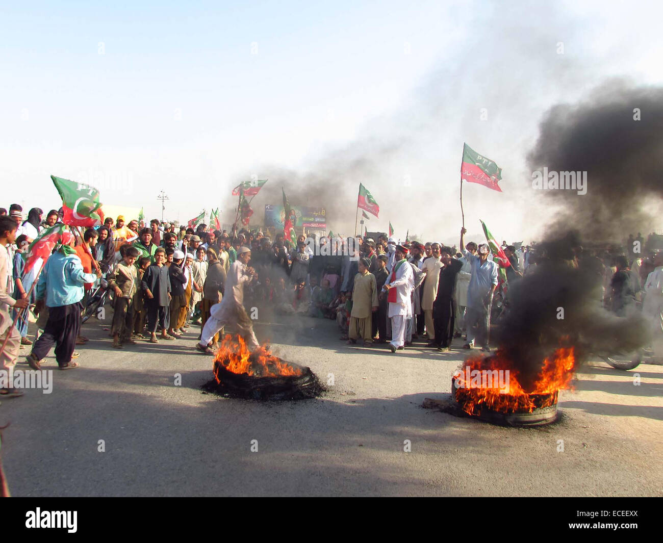 Aktivisten der Tehreek-e-Insaf Reifen in Brand gesteckt und blockierte National Highway bei Protest nach der geplanten Schließung ist eine Fortsetzung der PTI Vorsitzender Imran Khan Push-to-die Regierung zur Durchführung einer Untersuchung über die angebliche Manipulation bei den Parlamentswahlen Mai 2013 in Karachi auf Freitag, 12. Dezember 2014 unter Druck zu setzen. PTI Aktivisten blockieren Hauptverkehrsadern von Karachi einschließlich Shahrah-e-Faisal, Super Highway und National Highway. Stockfoto