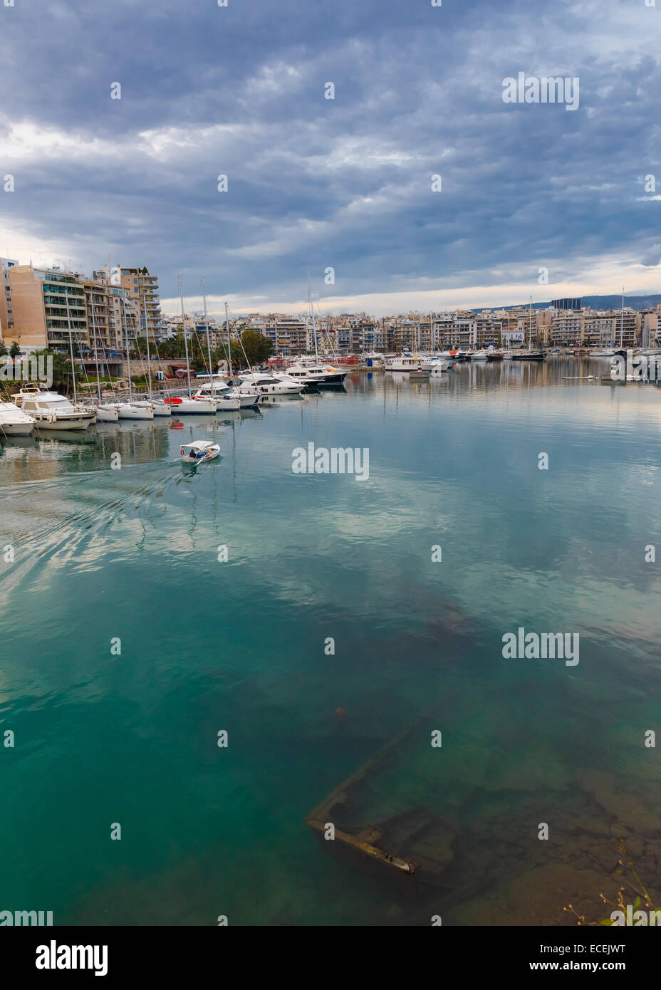 Versunkenes Fischerboot unter Wasser, im Hafen von Zea Marina in Griechenland mit einem vorbeifahrenden Fischerboot im Hafen wieder verlassen Stockfoto