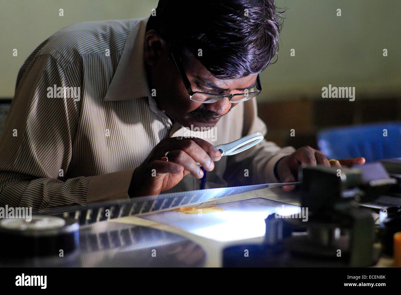 Pune, Indien. 25. November 2014. Eine alte indische schwarze & weiß Film Drucken von Kiran Dhiwar, Erhaltung Filmoffizier am Tisch Film Inspektion überprüft wird. © Subhash Sharma/ZUMA Wire/ZUMAPRESS.com/Alamy Live-Nachrichten Stockfoto