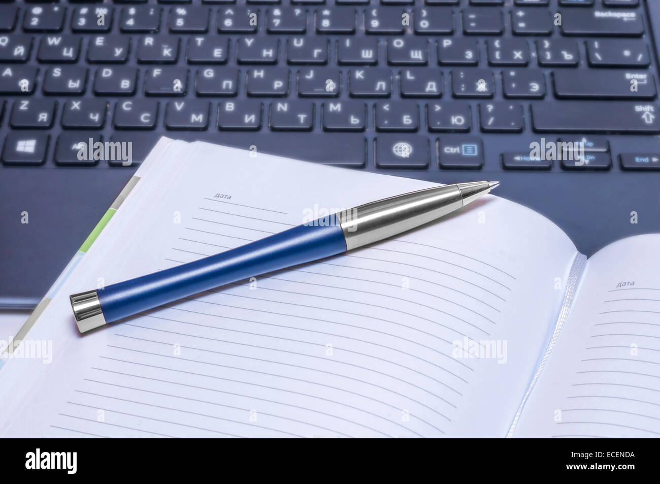 Notizbuch und Stift auf der schwarzen Tastatur. Hautnah. Stockfoto