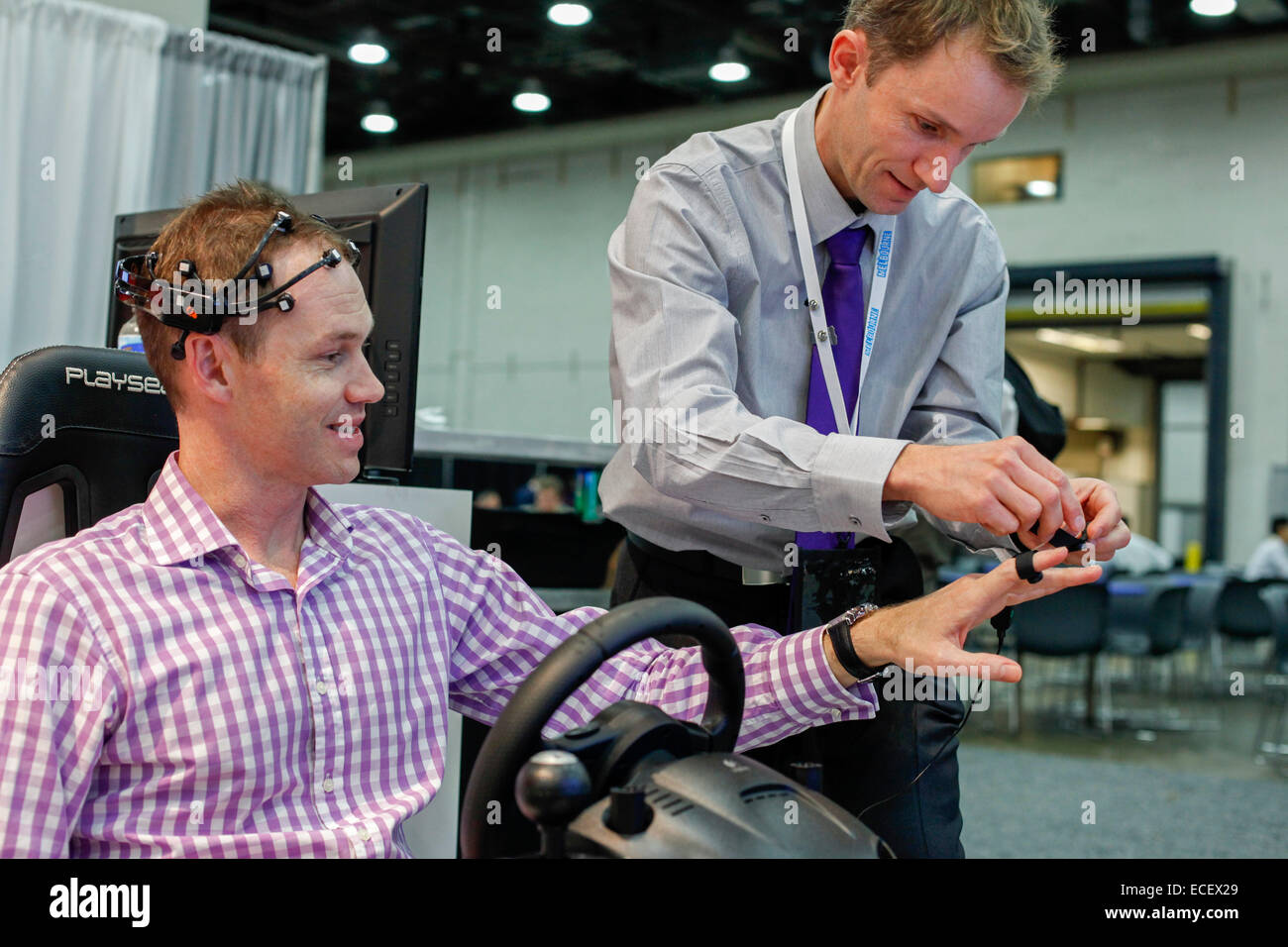 Ein Thema trägt Sensoren um seinen Geisteszustand bei Ablenkungen während des Betriebs eines Fahrsimulators zu überwachen. Stockfoto