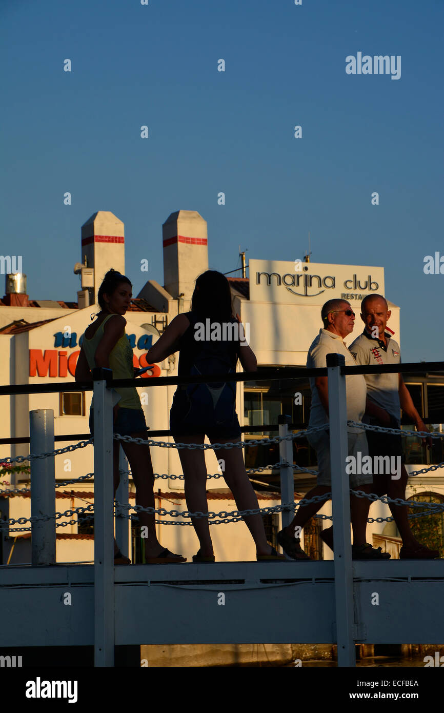 Zwei Mädchen in Silhouette im Chat auf einer Fußgängerbrücke im türkischen Badeort Marmaris Stockfoto