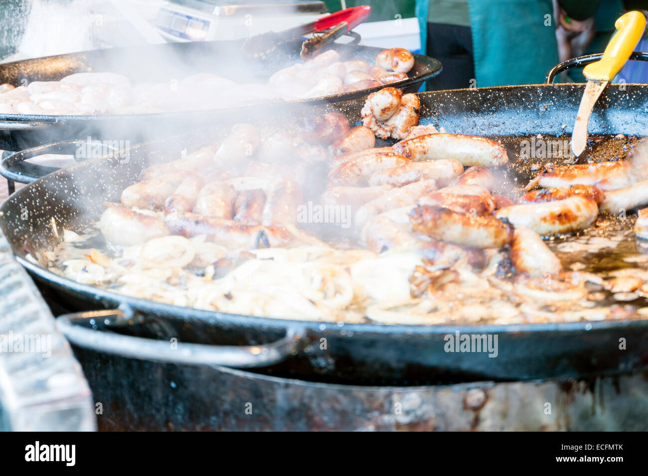 Würstchen & Zwiebeln Kochen in einer riesigen Pfanne schwenken, außerhalb catering, UK. Stockfoto