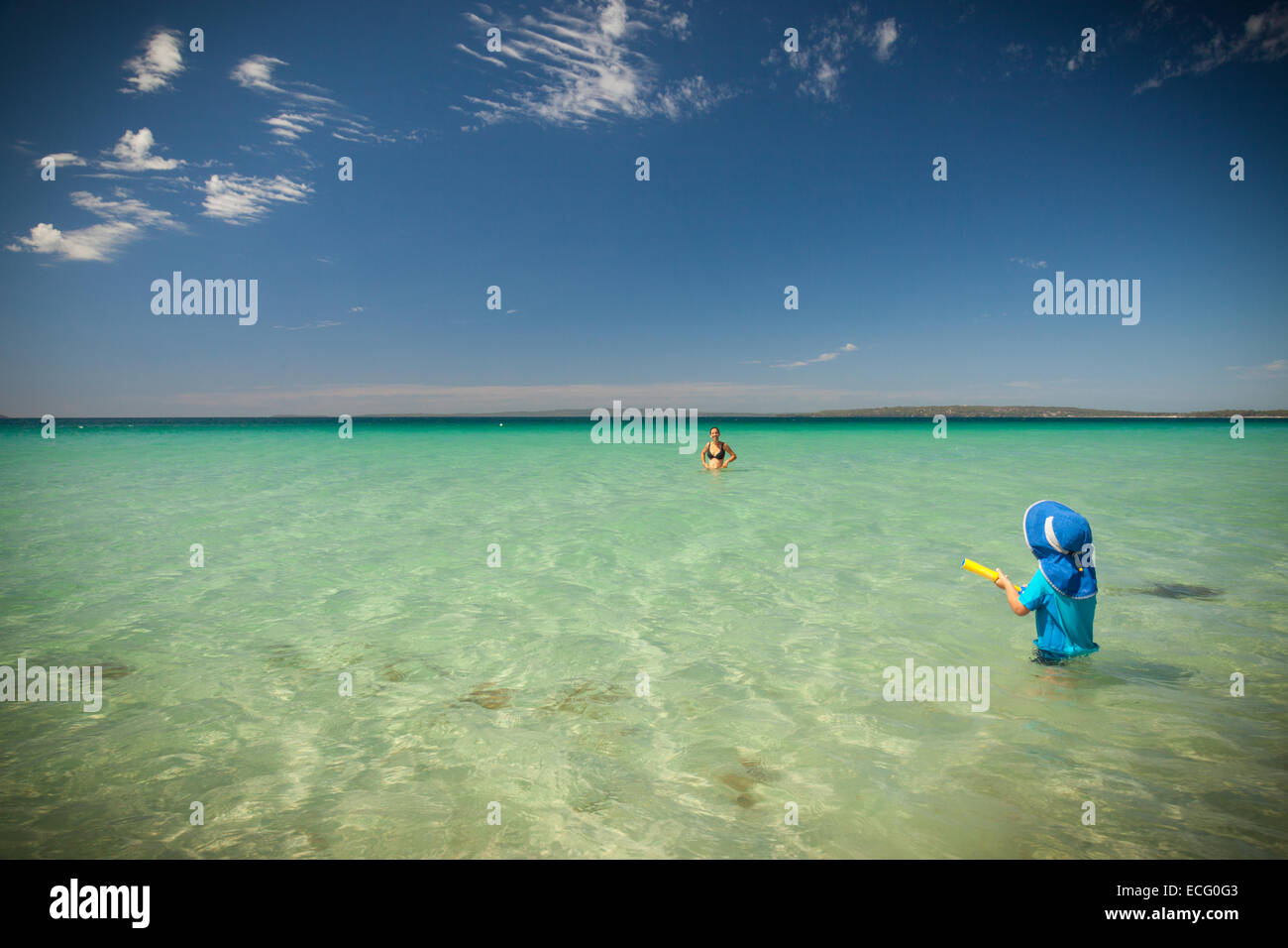 Mutter und Sohn spielt im Ozean mit einer Wasserpistole Stockfoto