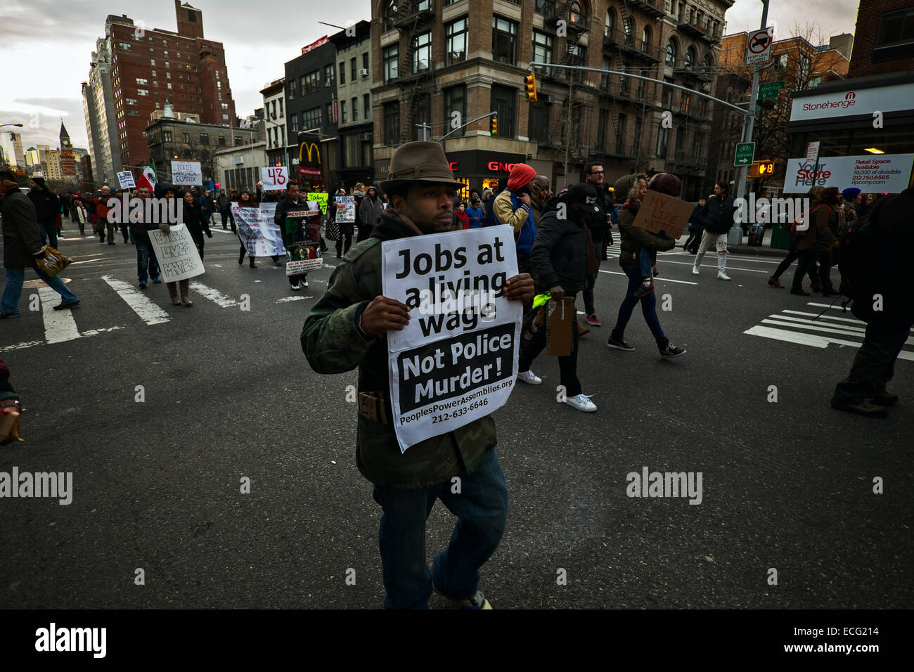 New York, USA. 13. Dezember 2014. Ein Mann hält ein Schild mit der Aufschrift, war "Arbeitsplätze auf einen existenzsichernden Lohn, nicht Polizei Mord!" einer von Tausenden von Menschen, die in New York City Straßen Protest gegen Polizeigewalt gegen schwarze marschierten. Bildnachweis: Joseph Reid/Alamy Live-Nachrichten Stockfoto