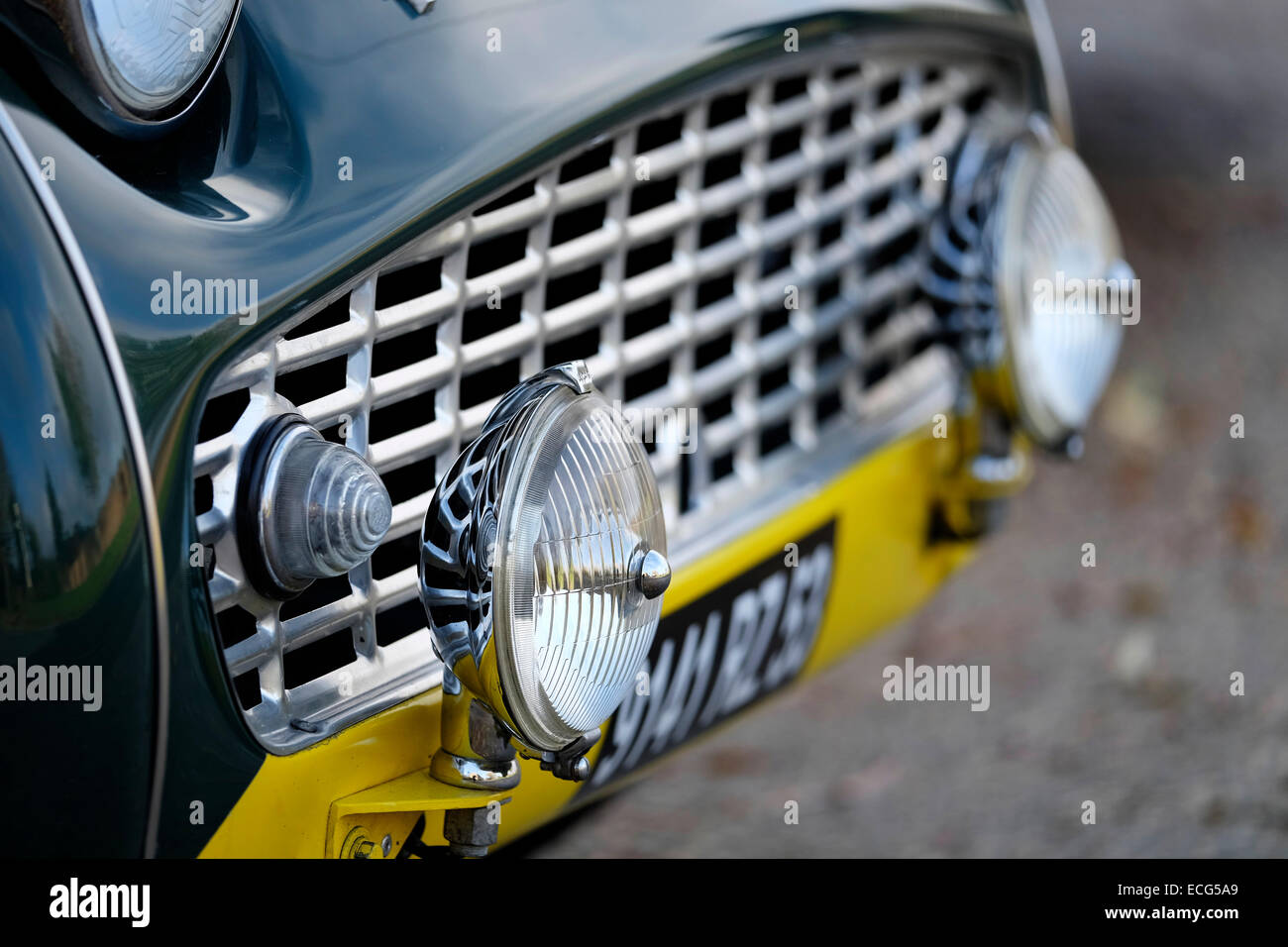 Lampen und Kühlergrill auf einem grünen Triumph TR3 klassischen Sportwagen fahren. Stockfoto