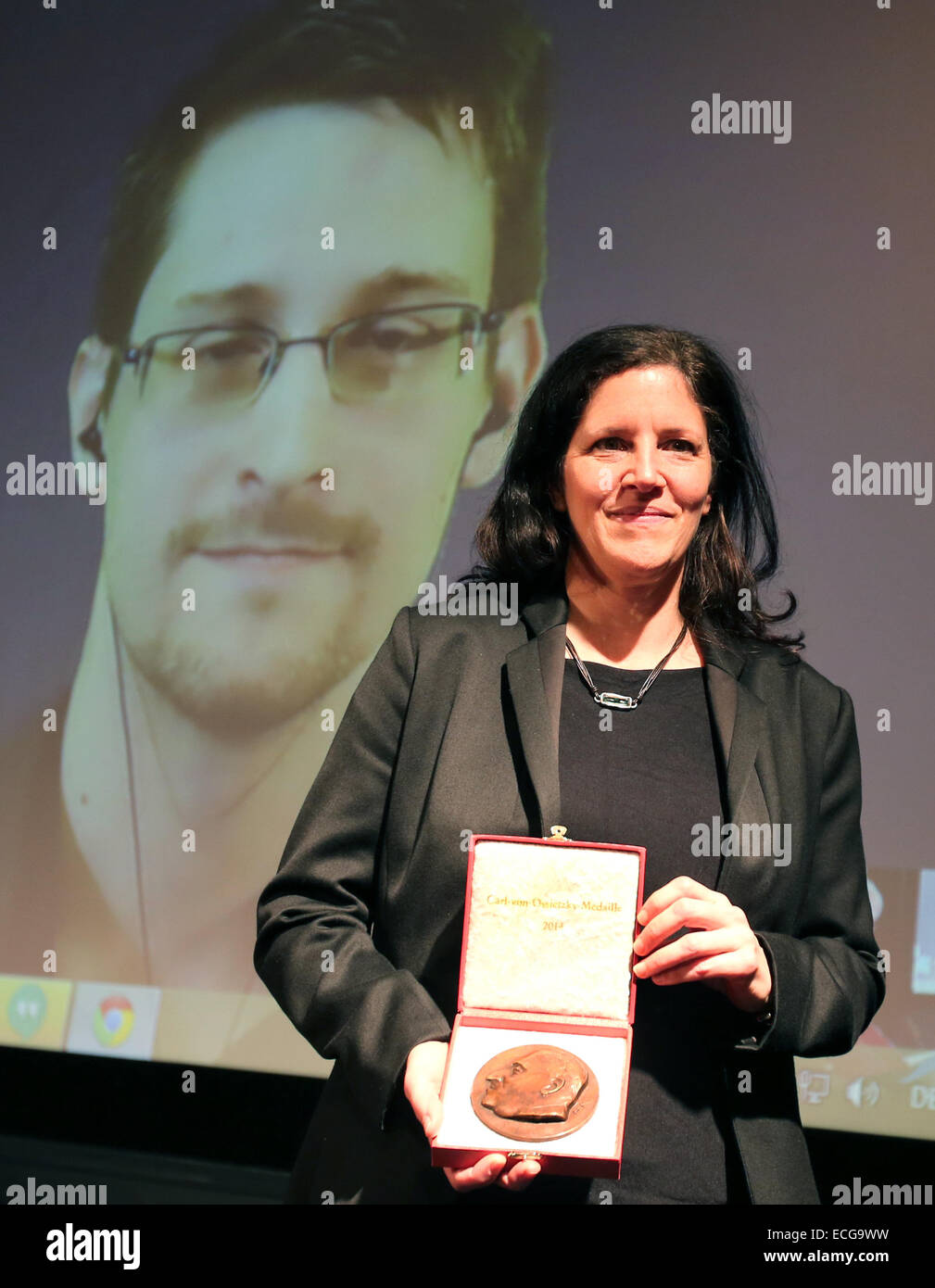 Berlin, Deutschland. 14. Dezember 2014. Dokumentarfilmer, die Laura Poirtras die 2014 Carl von Ossietzky-Medaille der internationalen Liga für Menschenrechte für NSA-Whistleblower Edward Snowden, hält, die im Hintergrund über gesehen werden kann live-Videoübertragung in Berlin, Deutschland, 14. Dezember 2014. Foto: WOLFGANG KUMM/Dpa/Alamy Live News Stockfoto