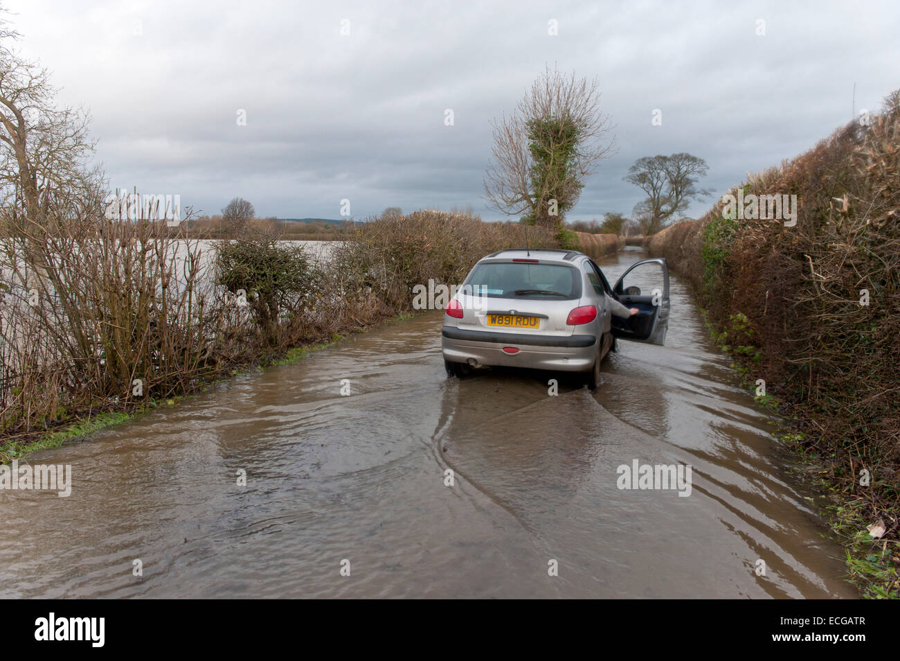 Atcham, Shropshire, UK. 14. Dezember 2014. Ein Auto fährt durch eine überflutete Gasse. Bildnachweis: Graham M. Lawrence/Alamy Live-Nachrichten. Stockfoto