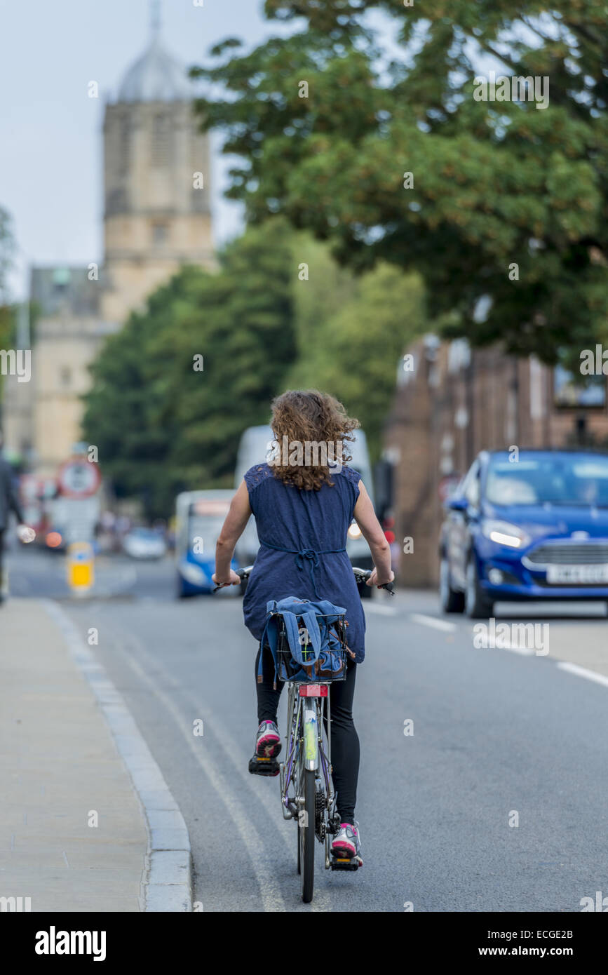 Eine junge Frau, vielleicht ein Student, Zyklen, St Aldate in der Universitätsstadt Oxford. Ist Tom Tower des Christ Church college Stockfoto