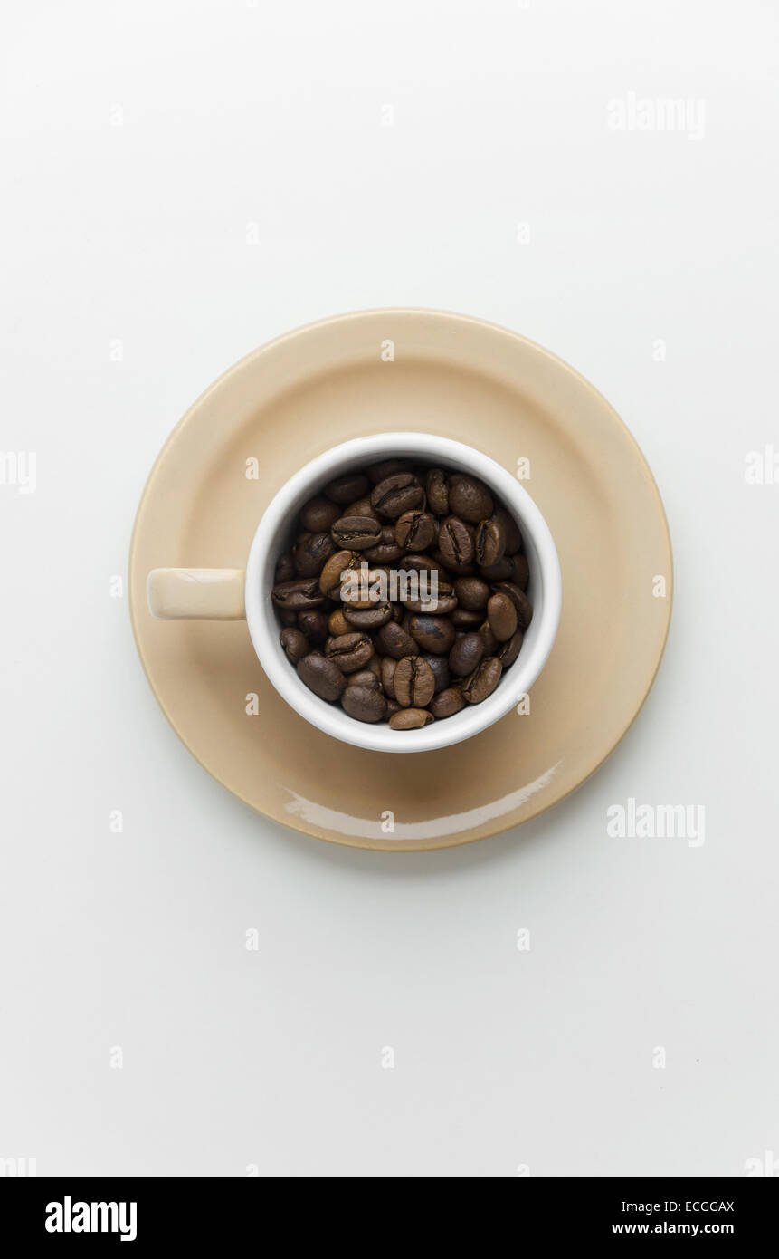 Kaffeebohnen in eine Tasse über weißen Tisch, über Ansicht Stockfoto