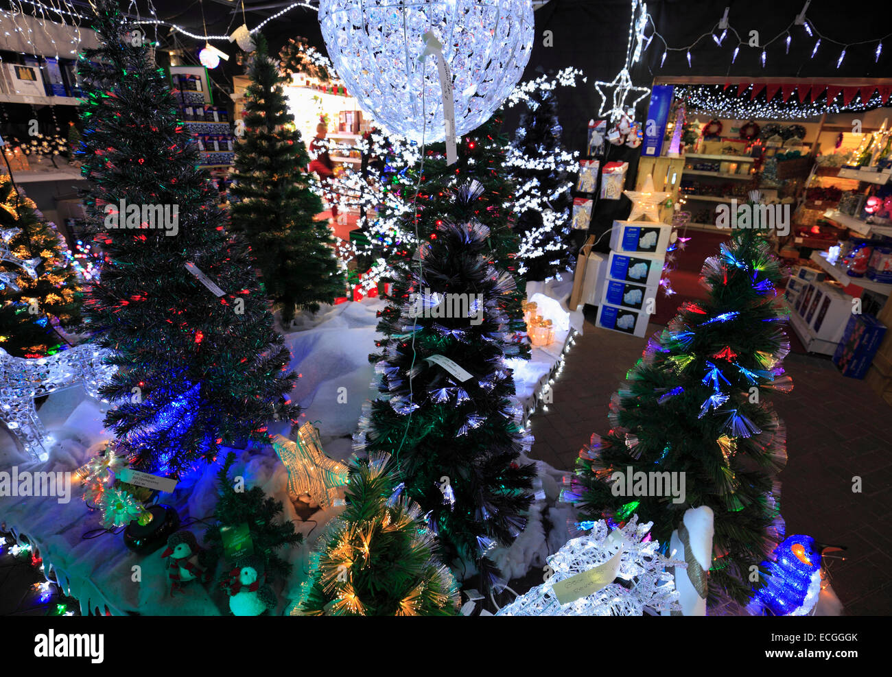 Künstliche Weihnachtsbäume und Dekorationen für den Verkauf in einem Geschäft. Stockfoto