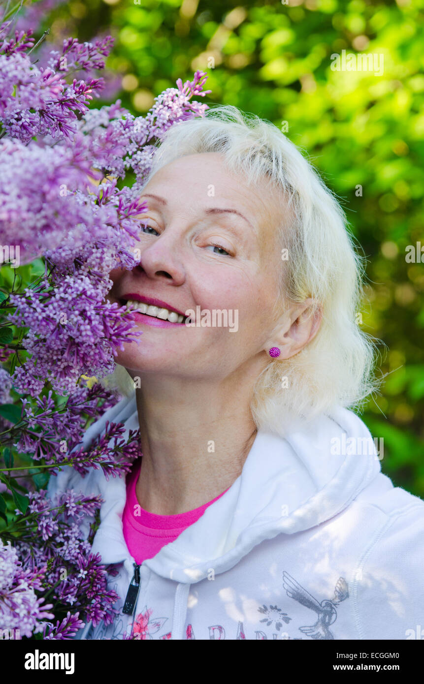 Porträt einer Frau aus einem Busch blühenden Flieder Stockfoto