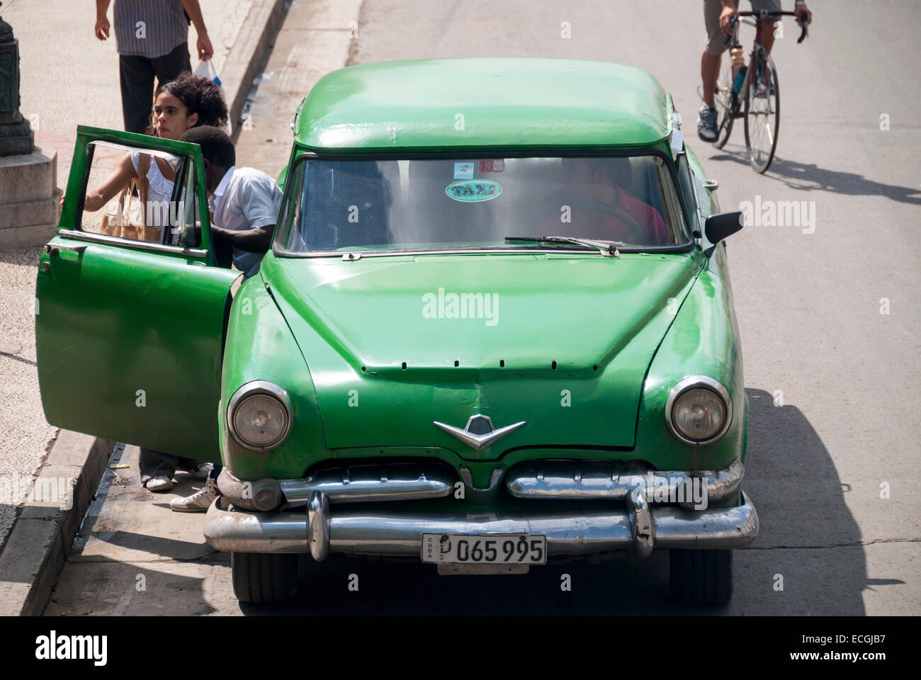Ein Mann und eine Frau Ausstieg eines amerikanischen Oldtimers verwendet als Taxi auf dem Prado in der Nähe von Parque Centrale in Havanna Kuba. Stockfoto