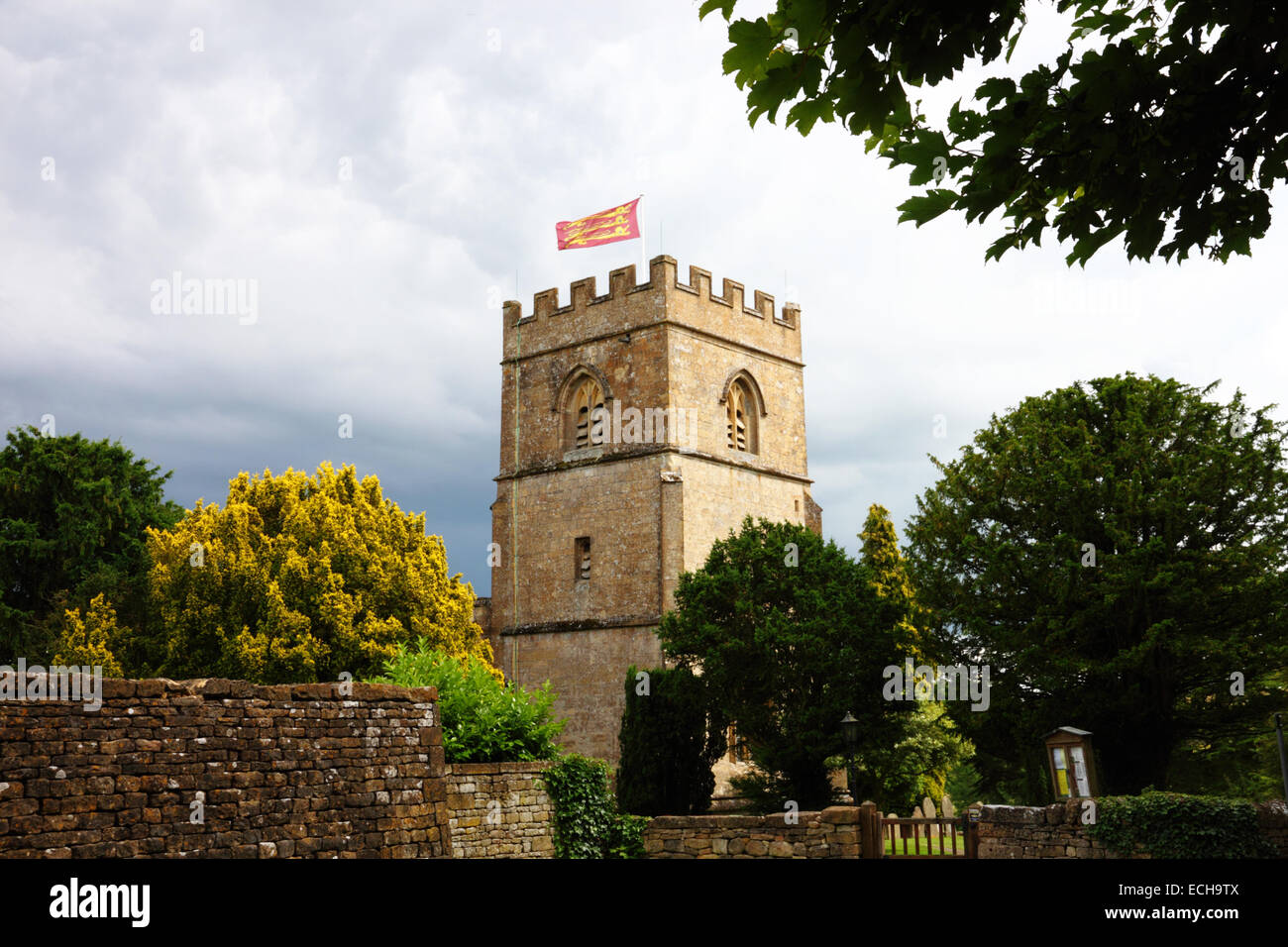 Eine Kirche mit einem gedrungenen Turm und eine Flagge, die in einen Feldweg. Stockfoto