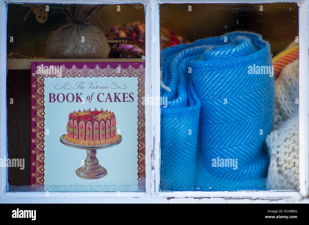 Ein Buch von Kuchen platziert in einem Schaufenster an der Seite eine blaue Wolldecke. Stockfoto