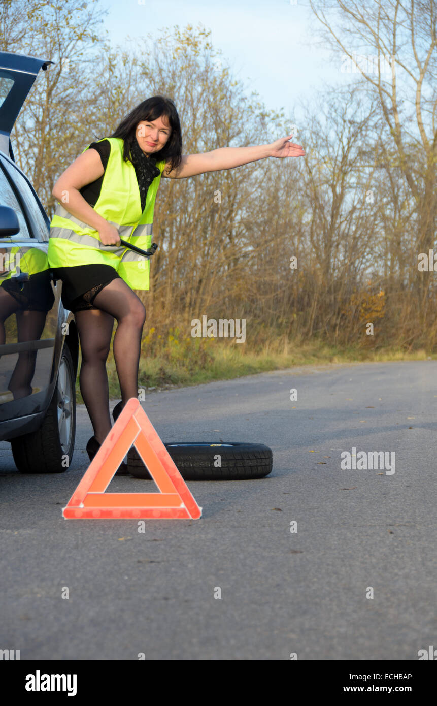 ein Foto einer Frau mit einem defekten Rad im Auto Stockfoto