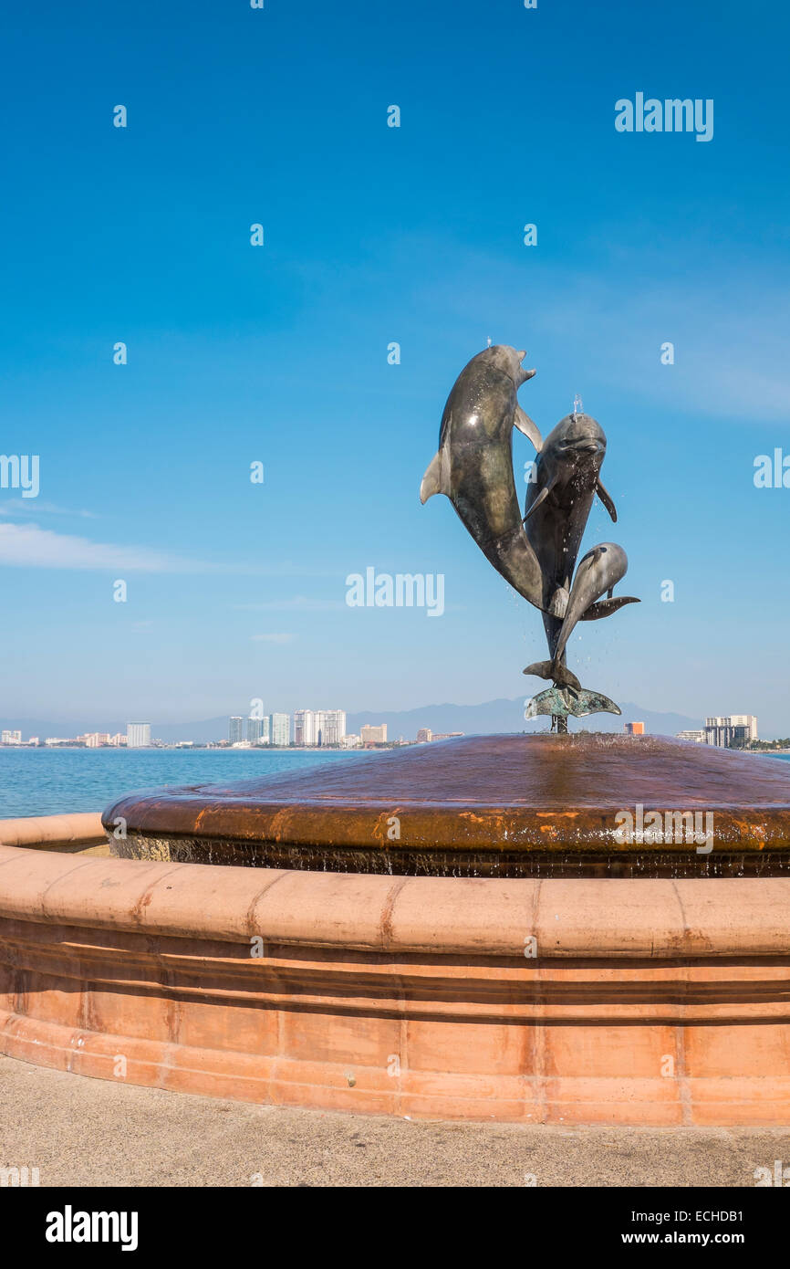 Delphin Familie Brunnen Statue auf dem Malecon in Puerto Vallarta, Mexiko. "Freundschaft Brunnen". Nuevo Vallarta im Hintergrund Stockfoto