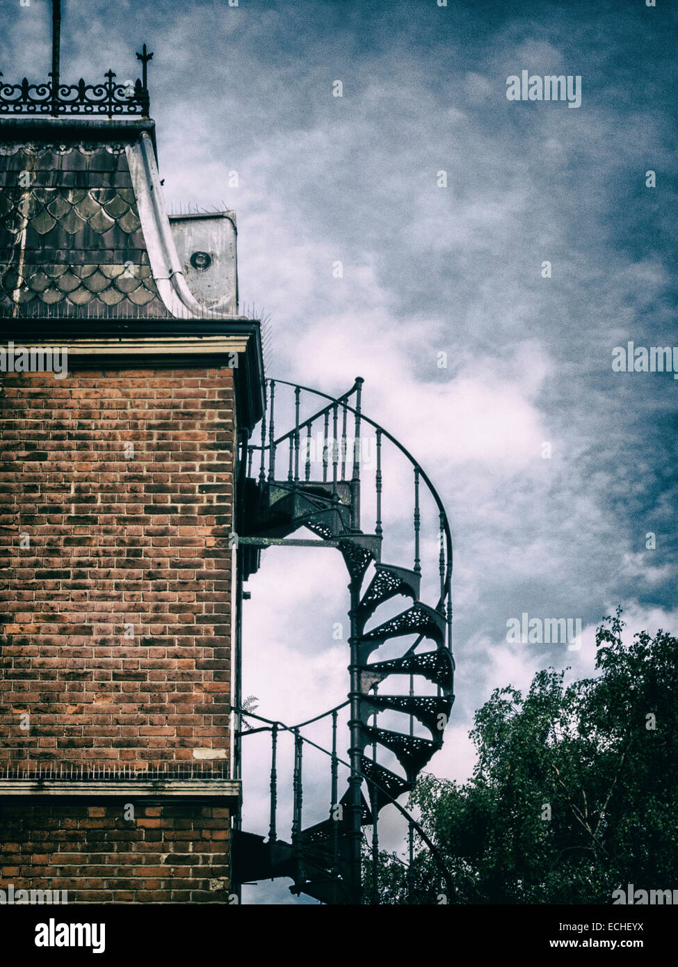 Haus Detail - kunstvolle Metallarbeiten Feuerleiter Treppen und Dach Detail vor dramatischen Himmel - Vorort von London UK Englisch Stockfoto