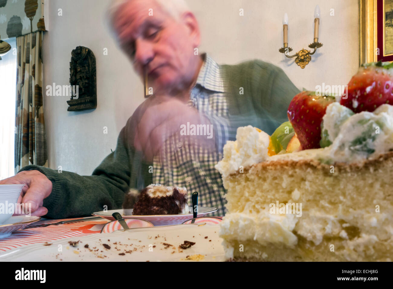 Sad sucht einsame ältere Menschen essen Geburtstagskuchen allein zu Hause in seinem Haus Stockfoto