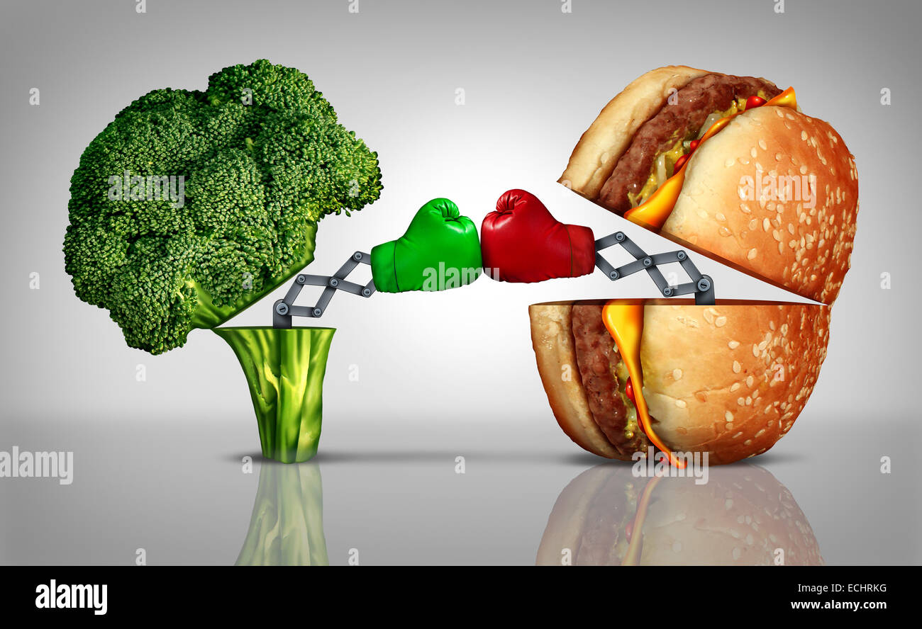 Essenskonzept Kampf Ernährung als eine frische gesunde Brokkoli kämpfen eine ungesunde Cheeseburger mit Boxhandschuhen von Schwellen- Stockfoto