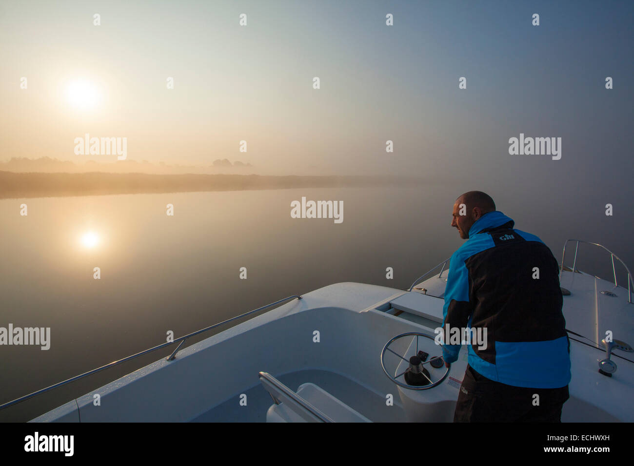 Person, die Navigation von einem Kreuzfahrt-Schiff über Lough Ree im Morgengrauen, Fluss Shannon, County Westmeath, Irland. Stockfoto