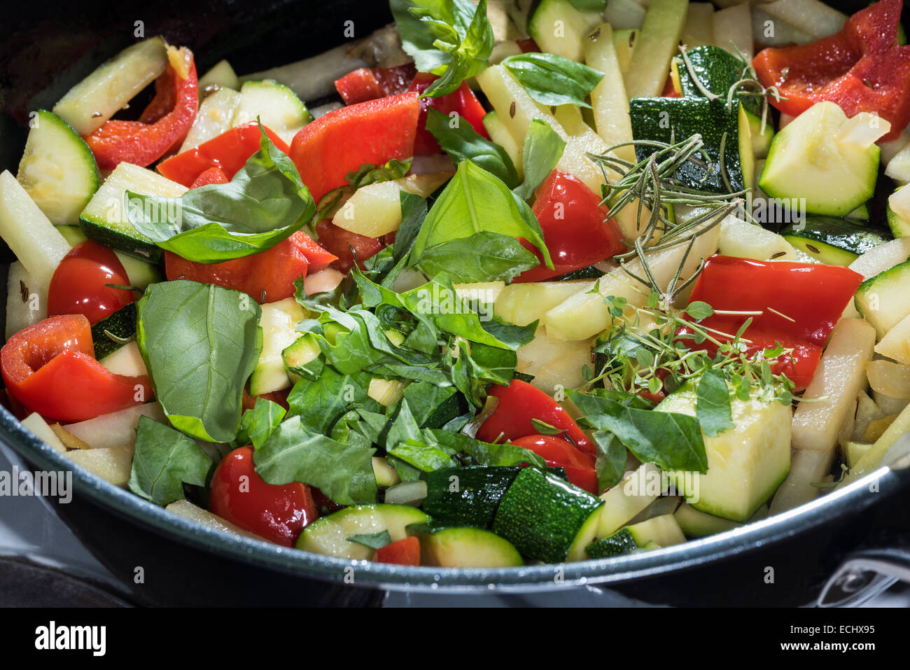 gemischtes Gemüse in einer Pfanne braten vorbereitet. Gesundheit gesunde Ernährung Kräuter Gewürze Zucchine Paprika Sellerie Basilikum Rosmarin Kreuzkümmel ki Stockfoto