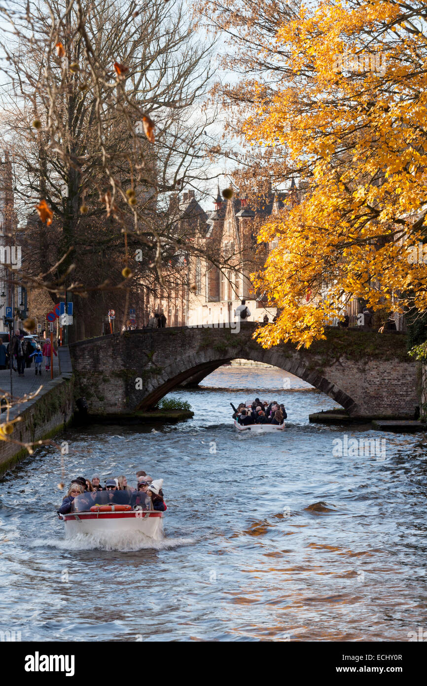 Touristen auf einer Bootsfahrt auf den Kanälen, im Herbst; Brügge, Belgien, Europa Stockfoto