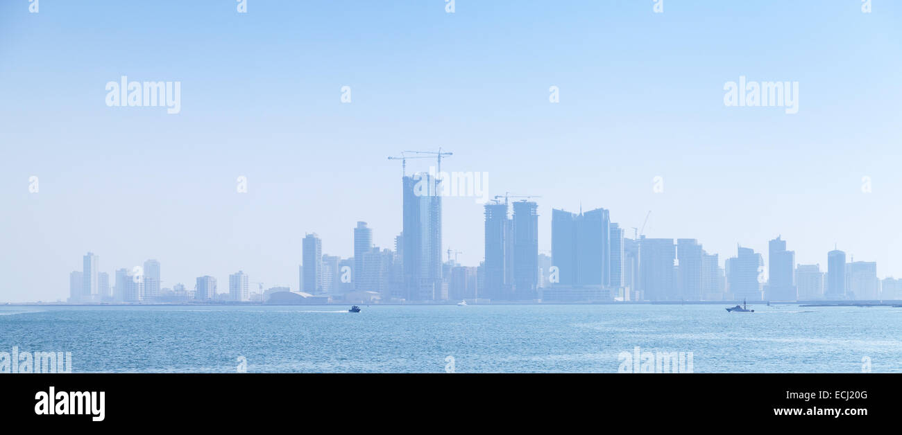 Skyline der Stadt Manama, Bahrain. Moderne Wolkenkratzer stehen im Dunst am Horizont Stockfoto