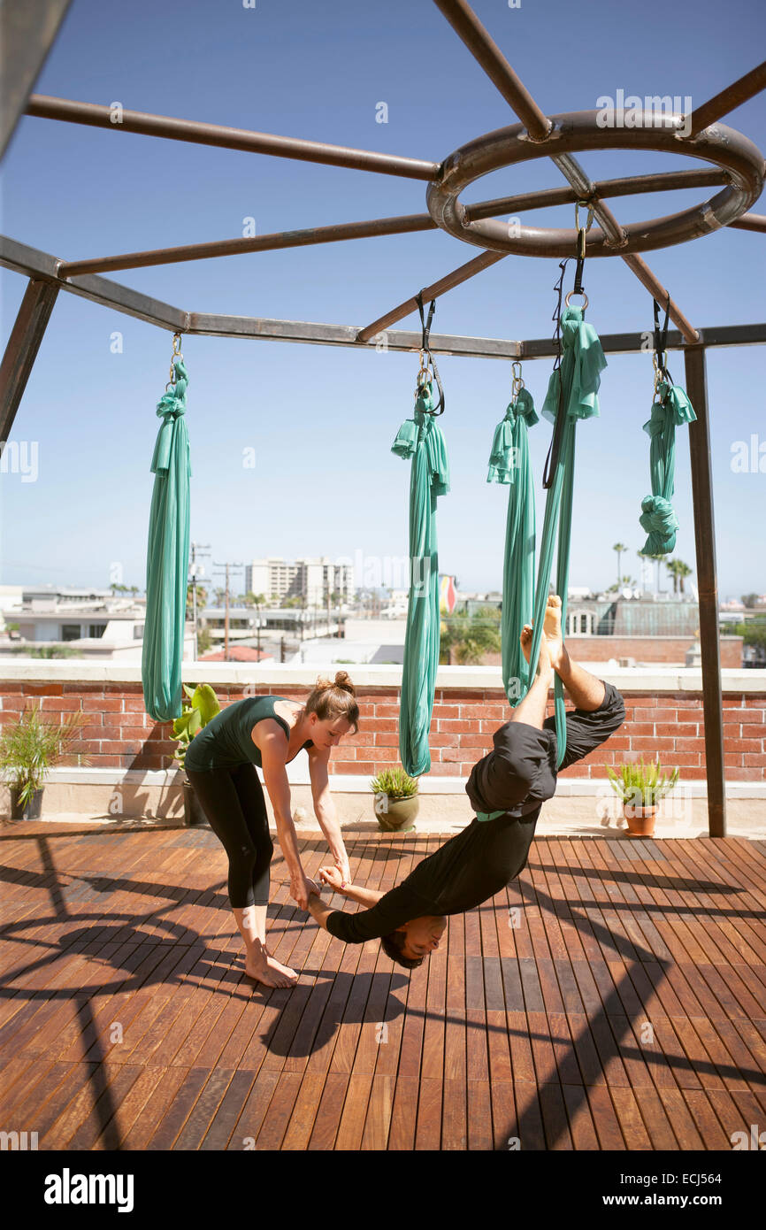 Ein schönes Mädchen und einen jungen Mann führen aerial Yoga. Stockfoto