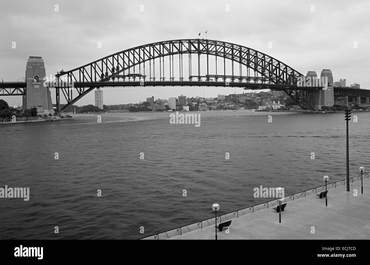 Drei leere Bänke vor riesigen ikonischen Stahl-Brücke. Stockfoto