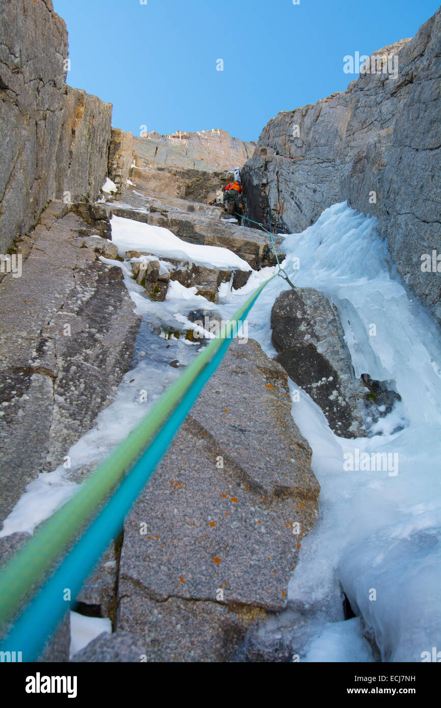 Ein Kletterer führt eine schwierige Eis klettern in früh fallen. Stockfoto