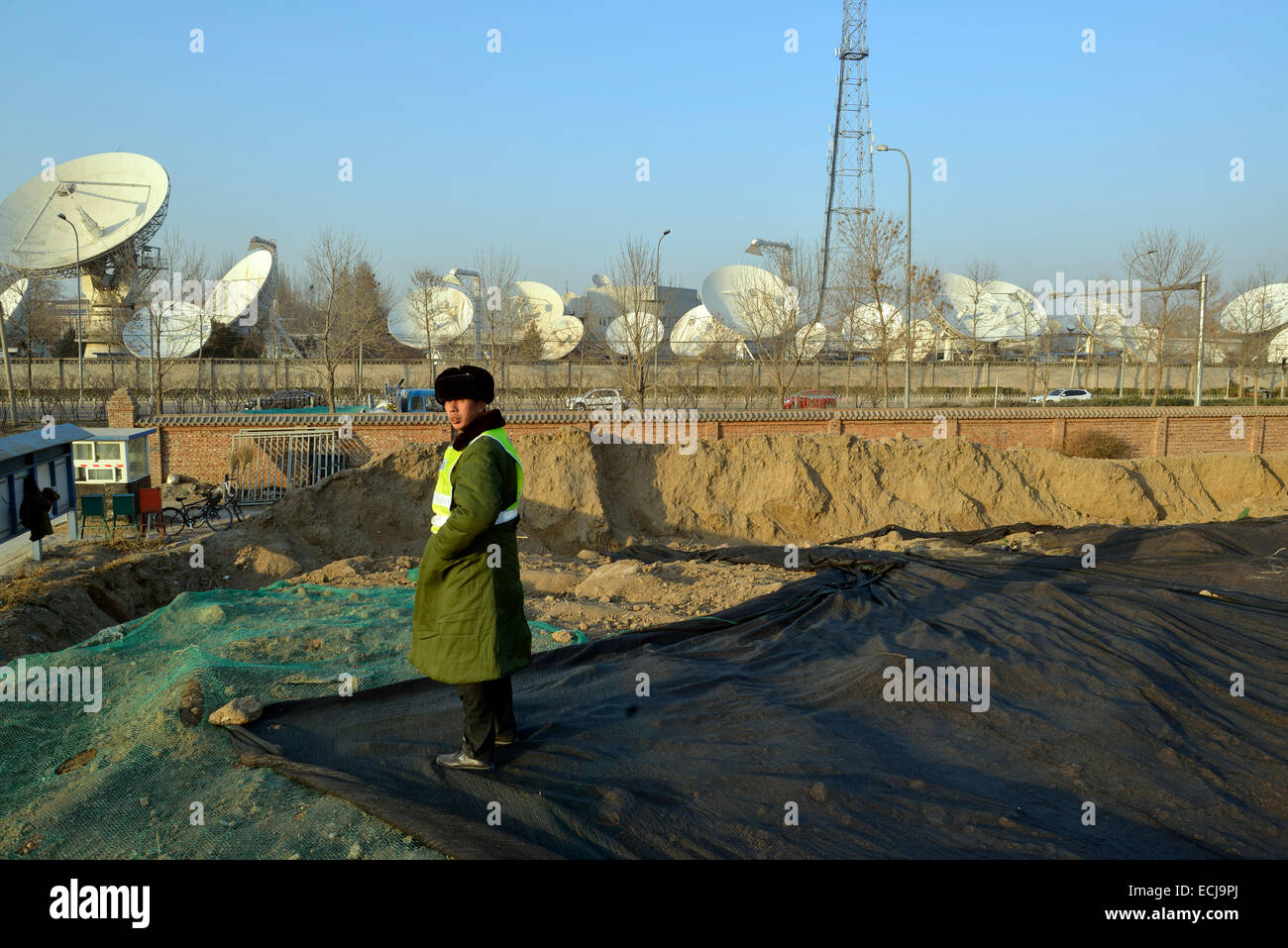 Ein Mann Wachpersonal in einer Baustelle in der Nähe von China Satellite Communications Co. Ltd. in Peking, China. 2014 Stockfoto