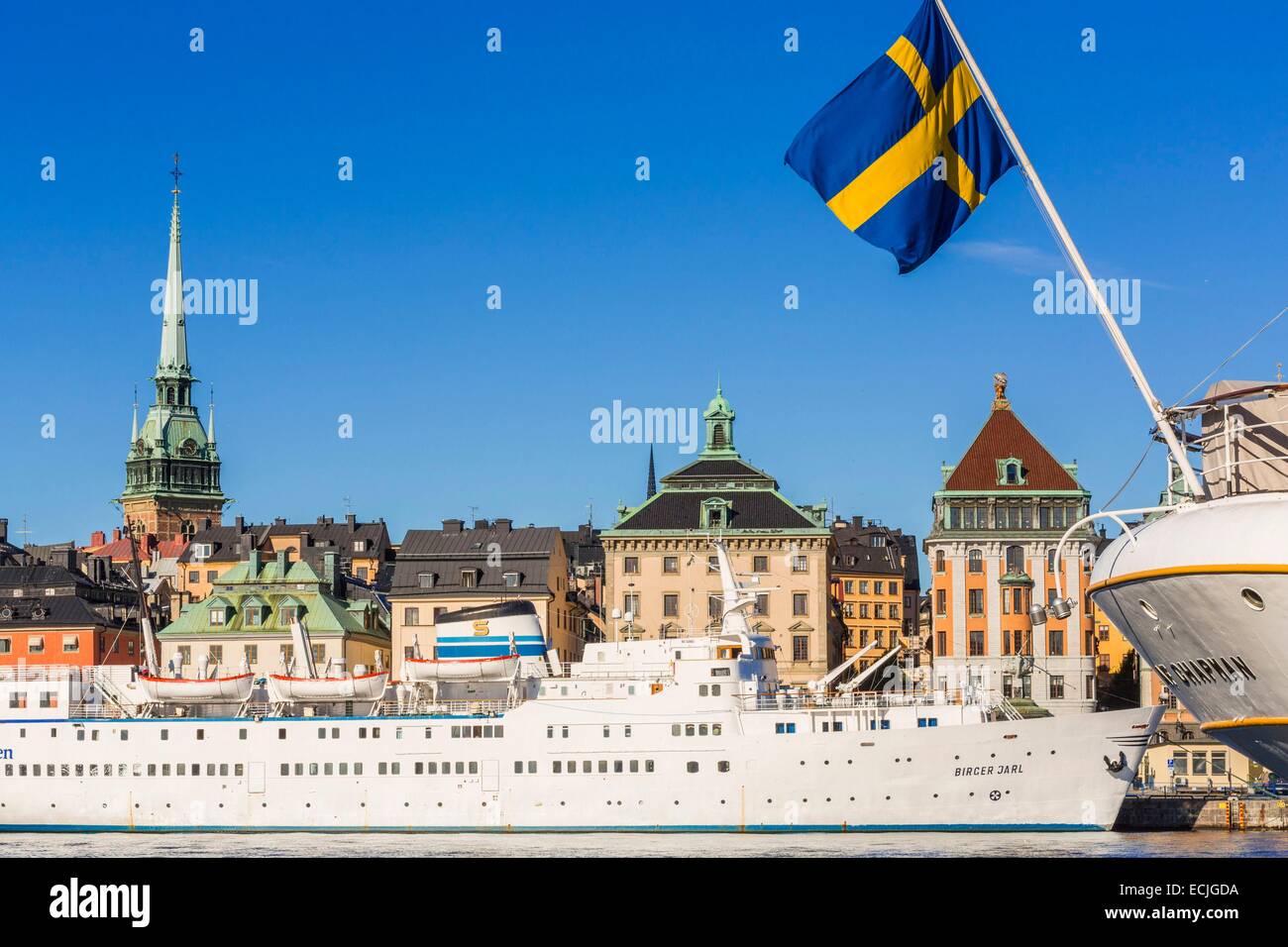 Schweden, Stockholm, Gamla Stan (Altstadt) und das Kreuzfahrtschiff, die, das MS Birger Jarl (1953) von der Insel Skeppsholmen im Vordergrund mit dem Heck von der Dreimaster angesehen, Schiff Af Chapman (1888) Stockfoto