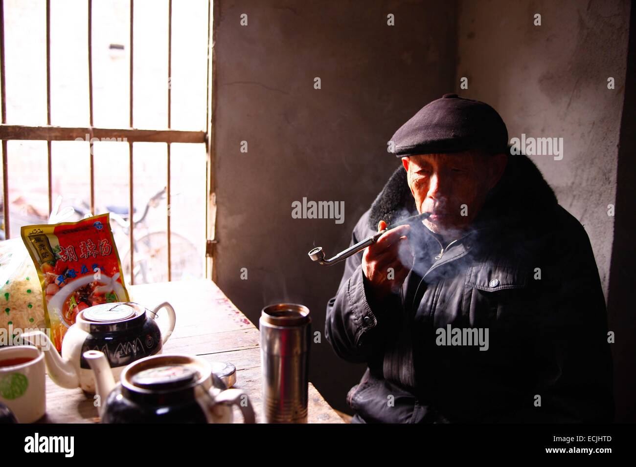 (141216)--HUAIBEI, 16. Dezember 2014 (Xinhua)--eine ältere raucht Pfeife in einem alten Teehaus im Osten Linhuan, Suixi Grafschaft von Huaibei Stadt, Kinn der Provinz Anhui, 11. Dezember 2014. Linhuan Stadt, gelegen im Südwesten der Grafschaft von Huaibei Suixi Stadt in der ostchinesischen Provinz Anhui, hat eine lange Geschichte, die vor mehr als viertausend Jahren stammt. Einheimische Bevölkerung der Linhuan hat die Tradition des Teetrinkens seit der Ming-Dynastie, die den Druck auf das Leben der Menschen hier durch die alten quadratischen Tisch, der grobe Sand Schüssel und die rostigen Kupfer Teekanne Blätter gehalten. Kunden zeigen in der Regel sich bei der t Stockfoto