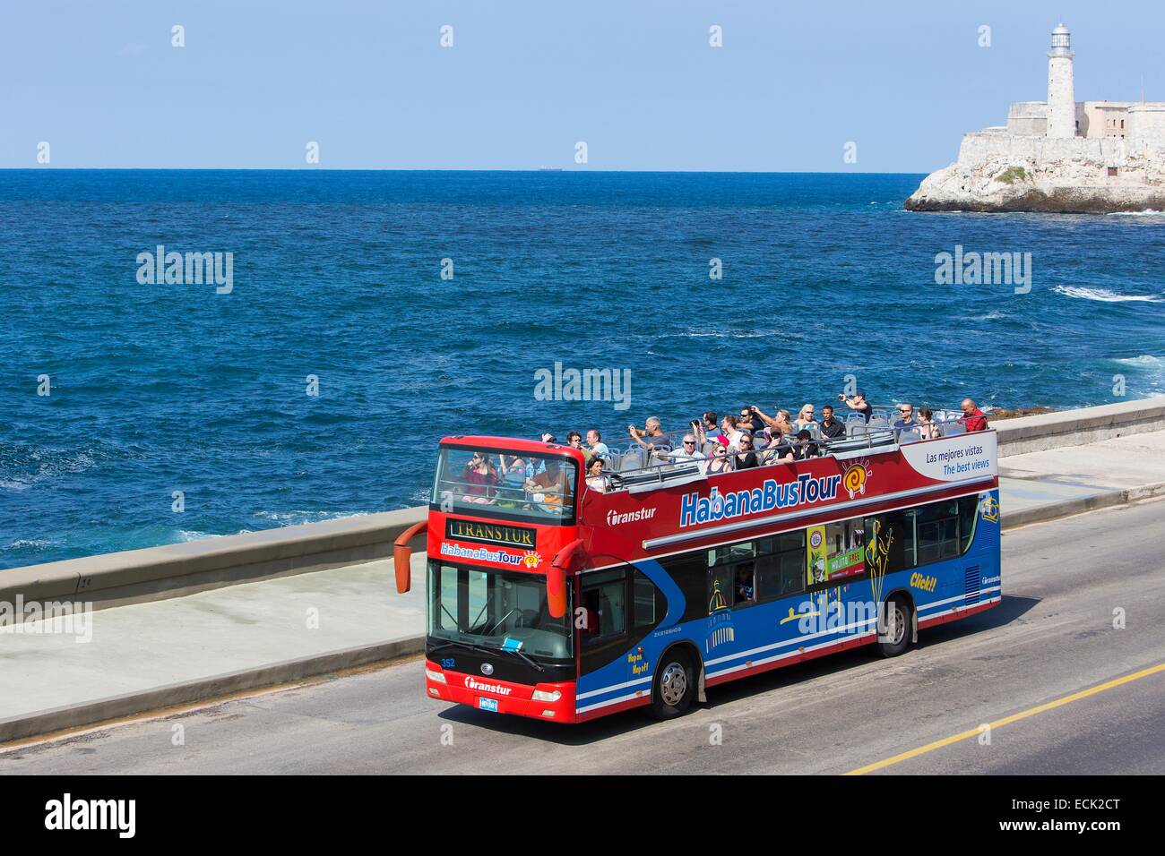 Kuba, La Habana, Touristen in einer City Tour Doppeldecker-Bus auf dem Malecon und Castillo de Los Tres Reyes Magos del Moro im Hintergrund Stockfoto